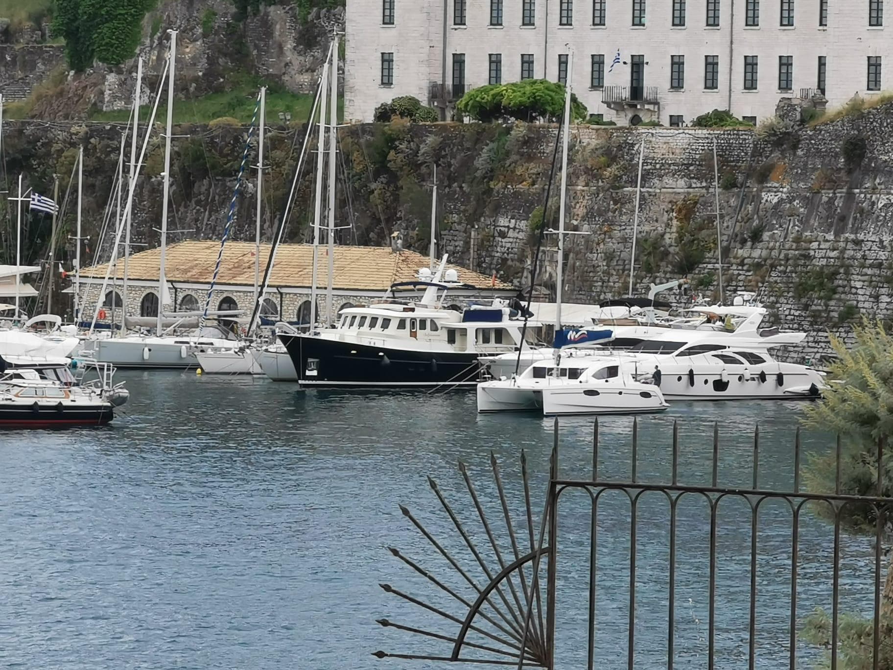 Boats docked in a scenic harbor with Almtrawler Delfino 65, 2015 model.