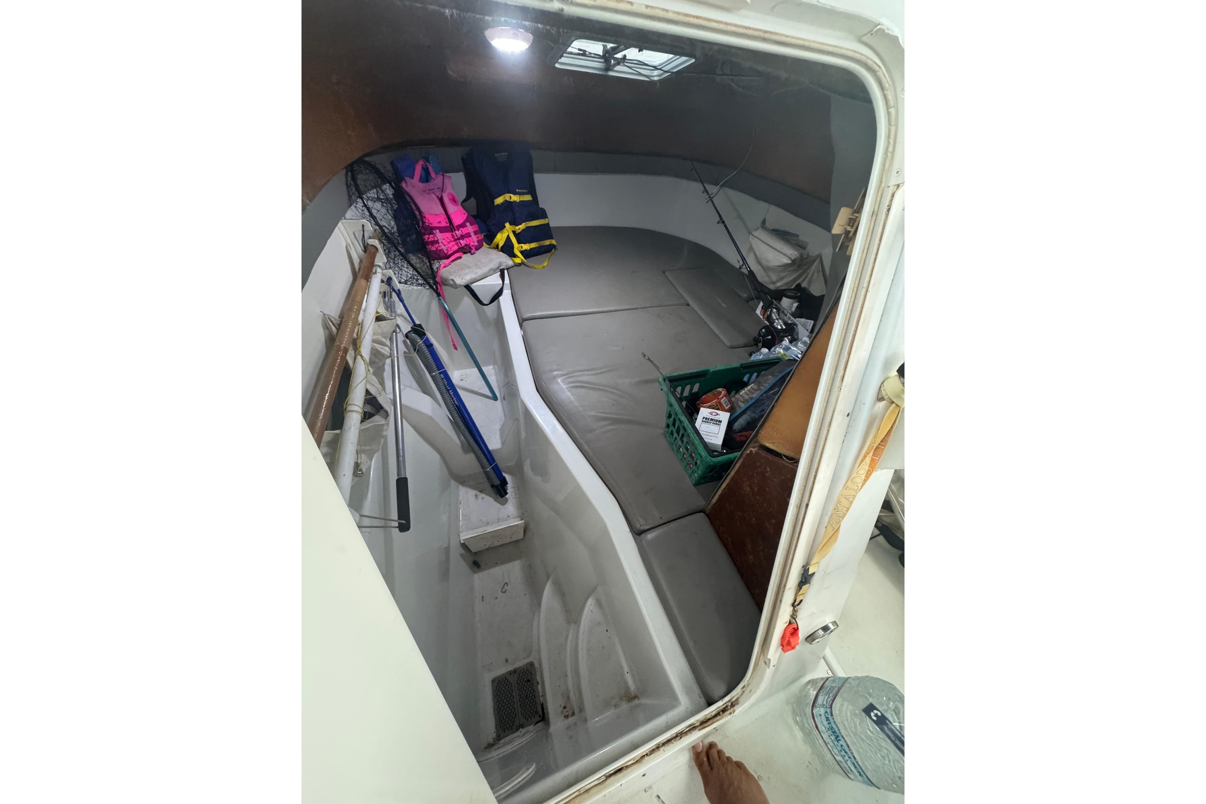 Interior of 2004 Glacier Bay 2270 Isle Runner boat with fishing gear and life jackets.