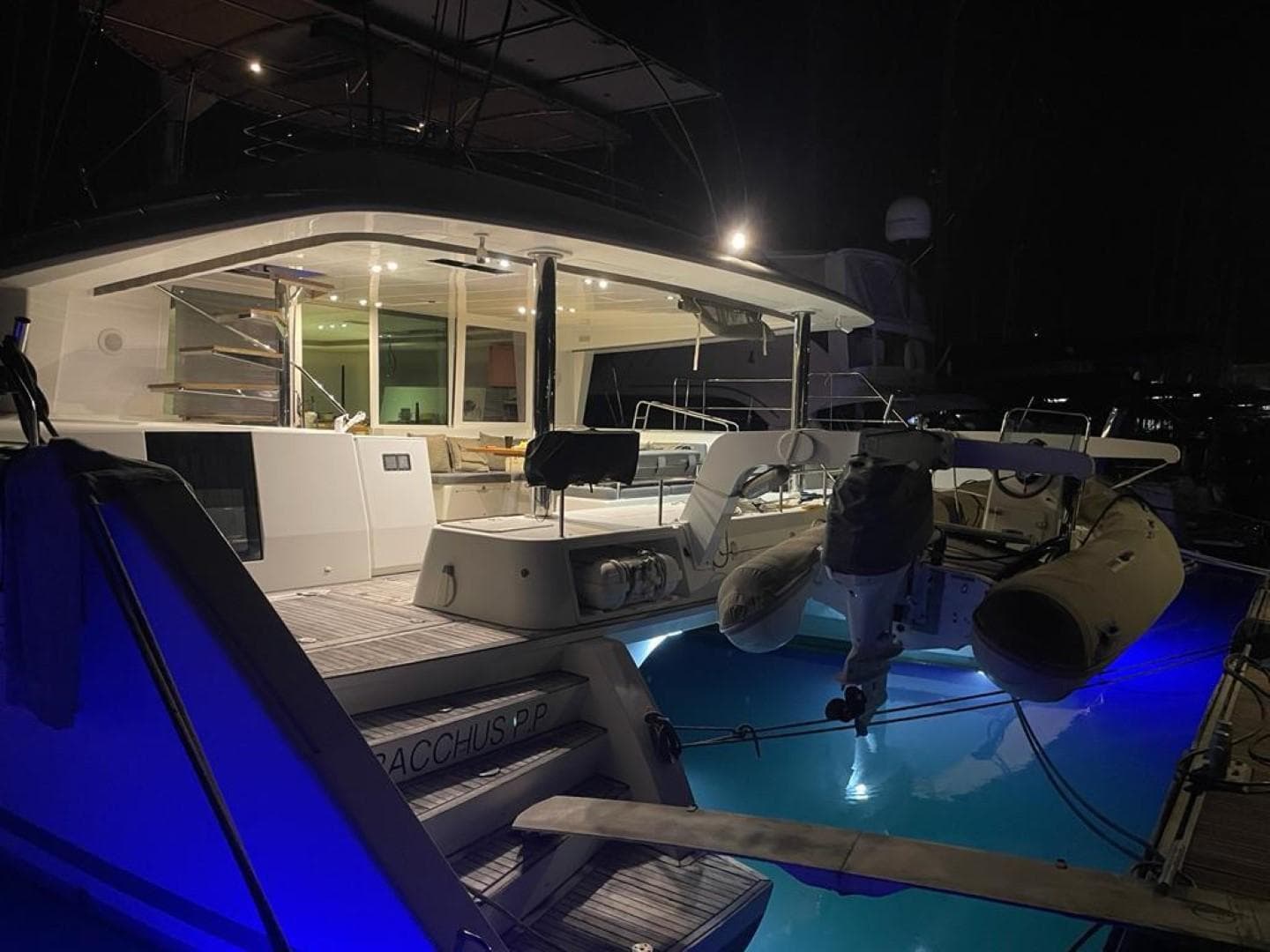 Lagoon 560 yacht, 2012 model, illuminated at night with blue underwater lights.