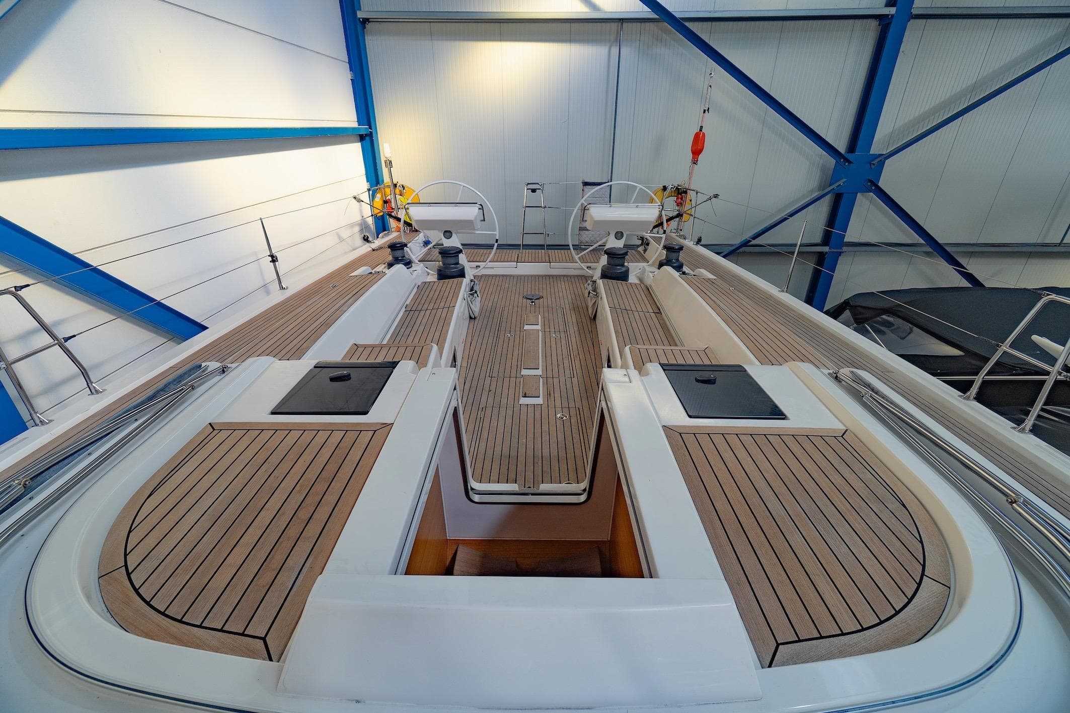 2014 X-Yachts Xp 55 sailboat with sleek teak deck in a modern indoor marina.