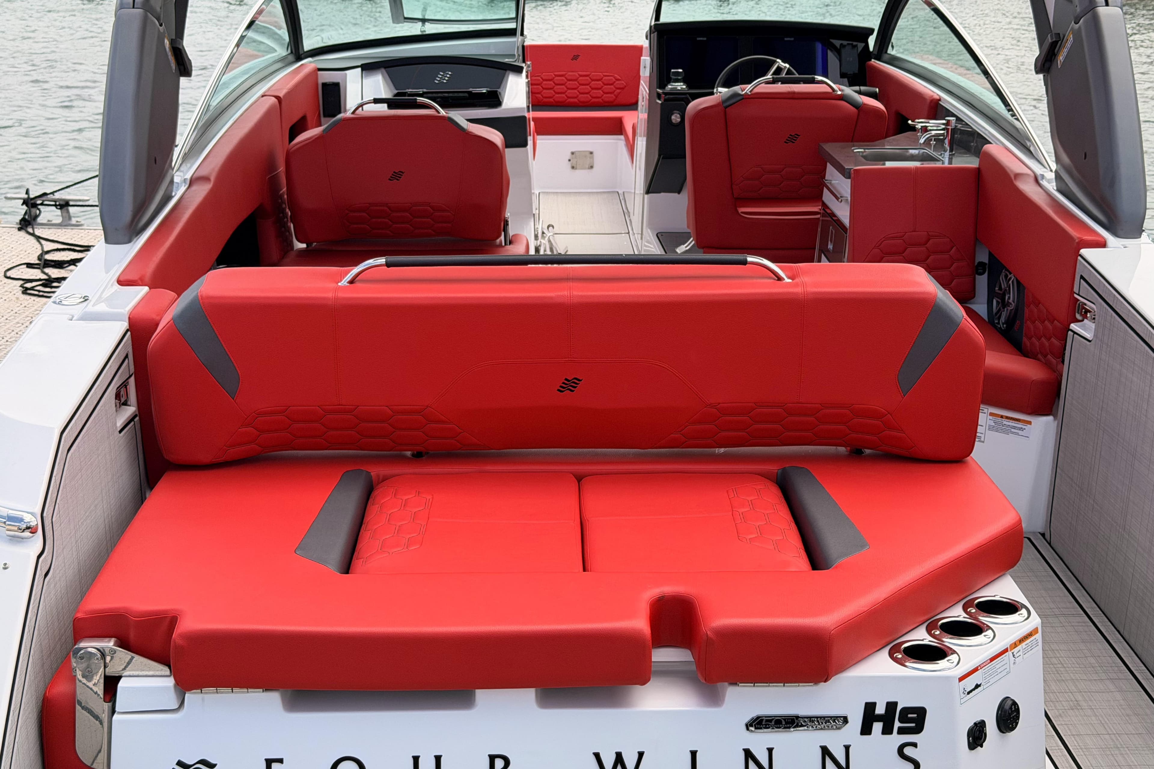 2025 Four Winns H9 OB boat with luxurious red seating and modern interior design.