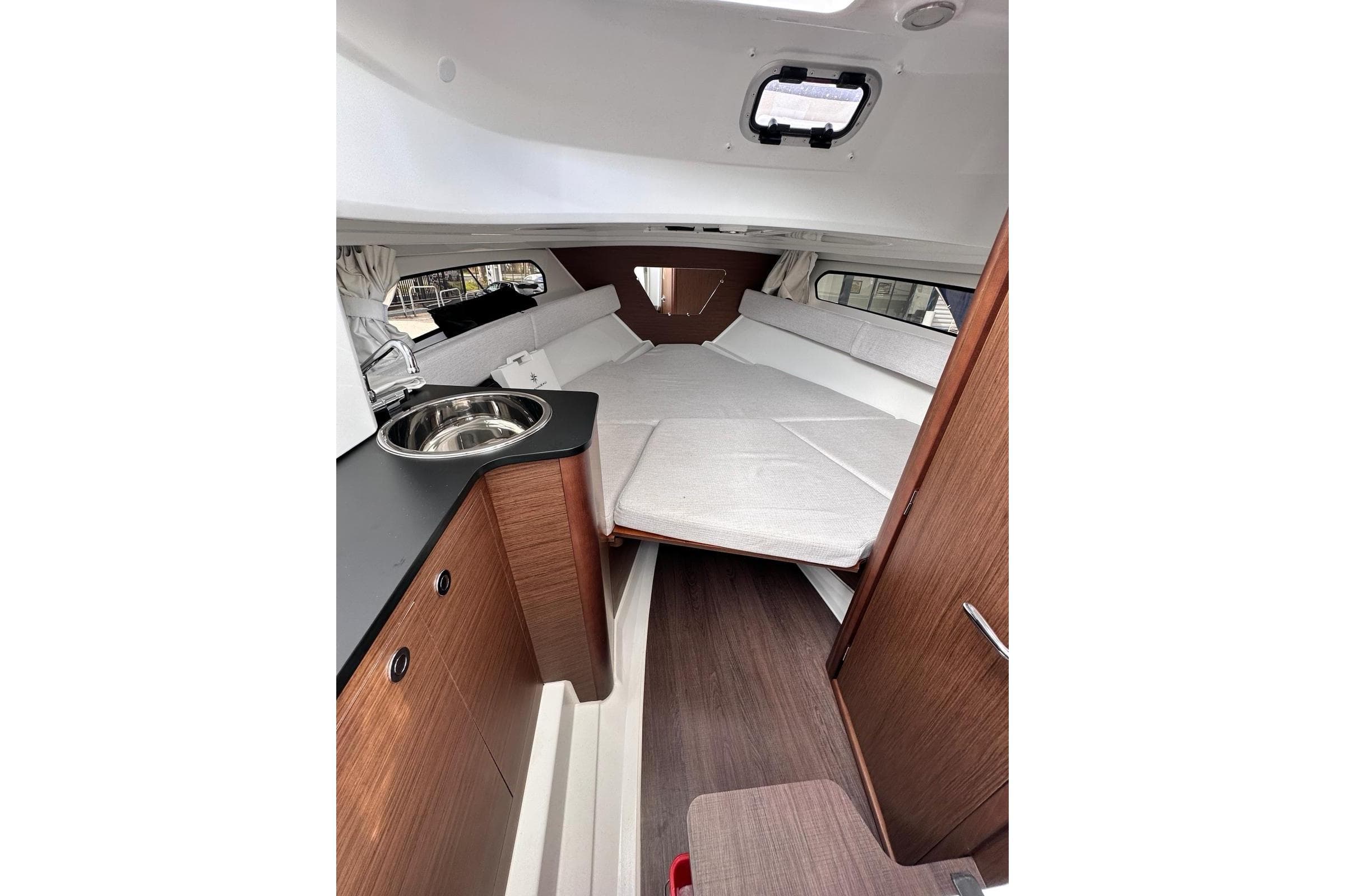 Interior of 2025 Jeanneau Cap Camarat 7.5 WA Serie 3, featuring cozy cabin and kitchenette.