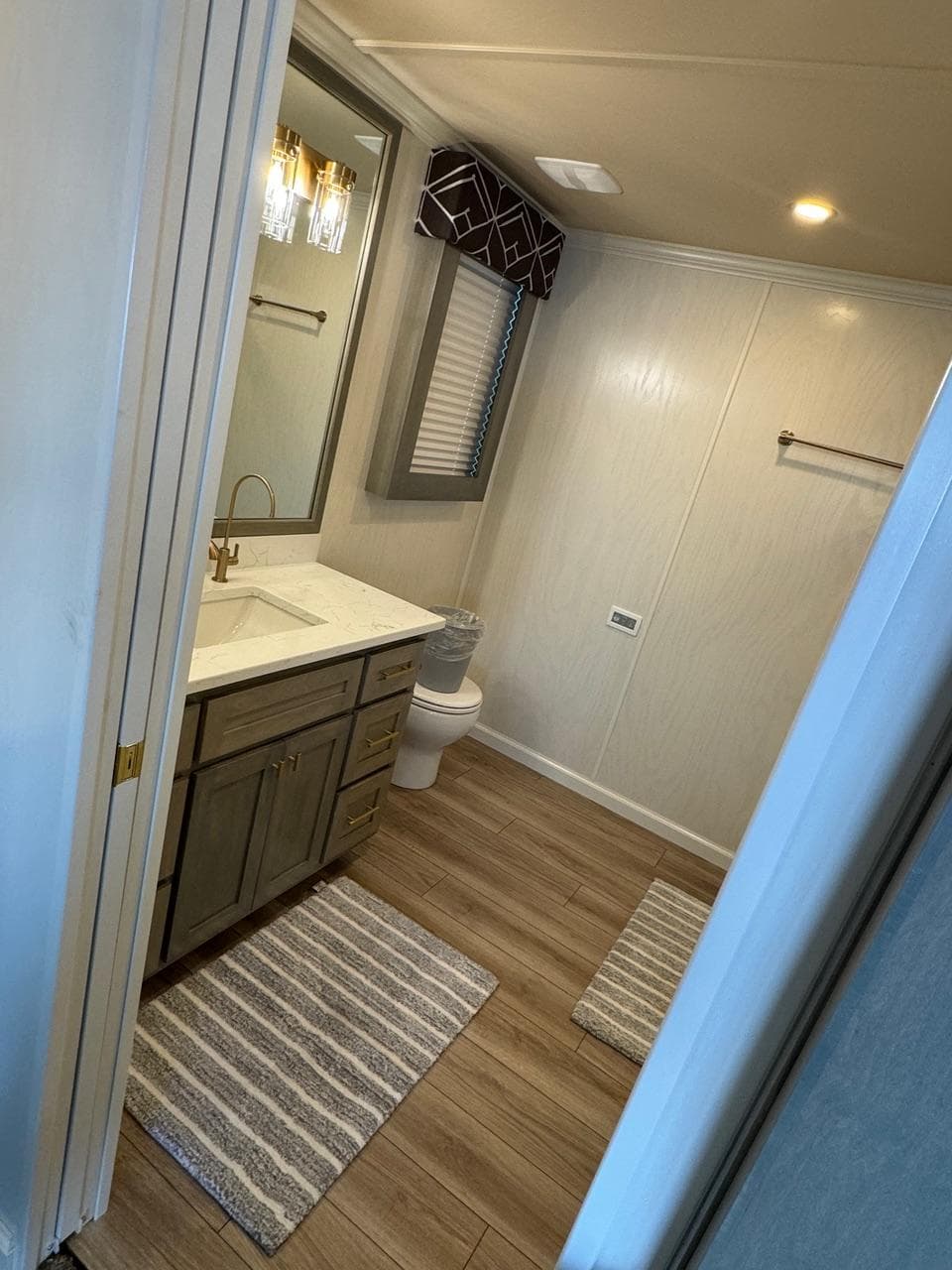 Modern bathroom in 2024 Sumerset Limitless Share 10 houseboat with wood flooring and elegant fixtures.