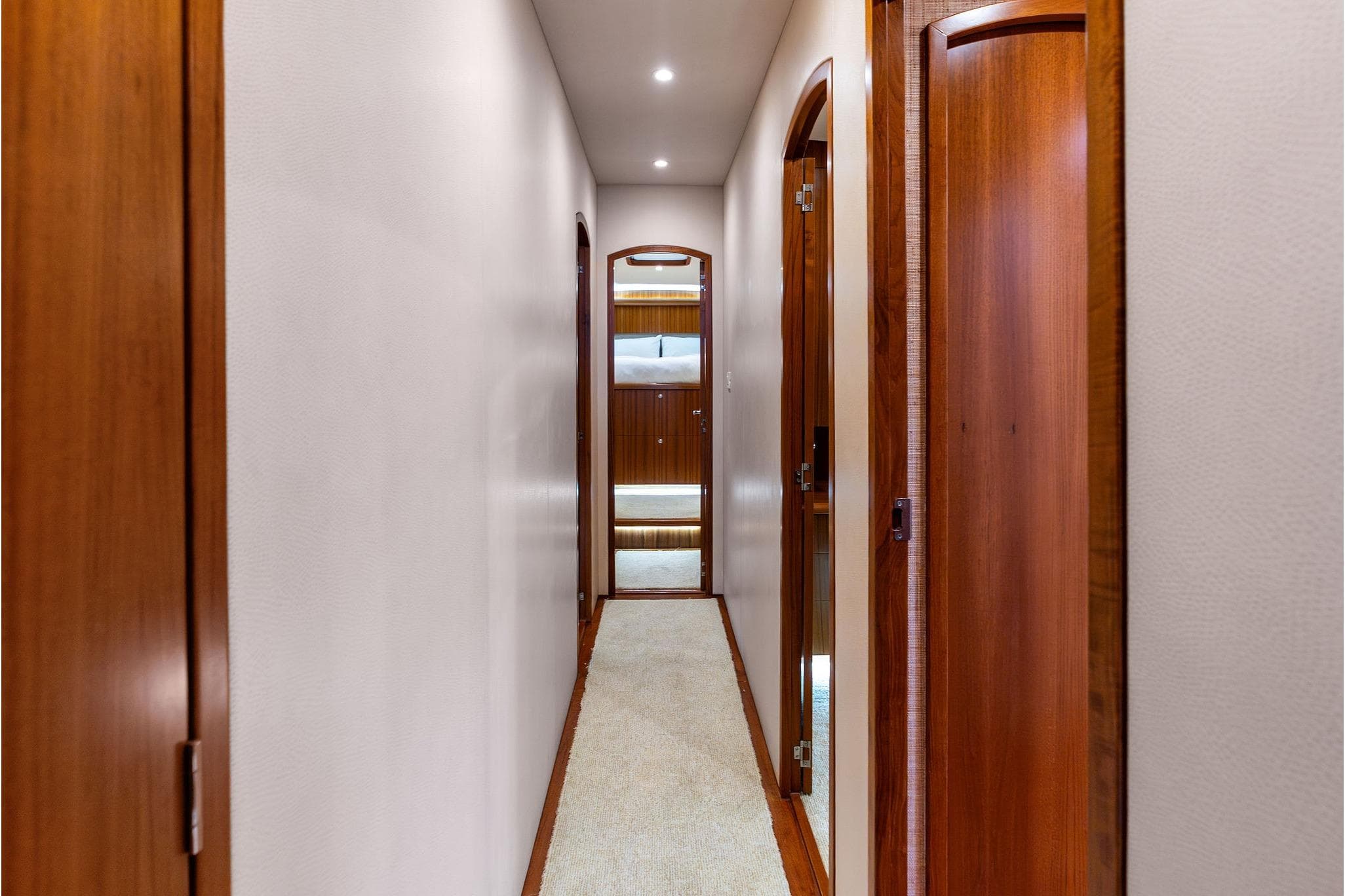 Hallway inside 2017 Weaver Custom Sportfish yacht with wooden doors and soft lighting.