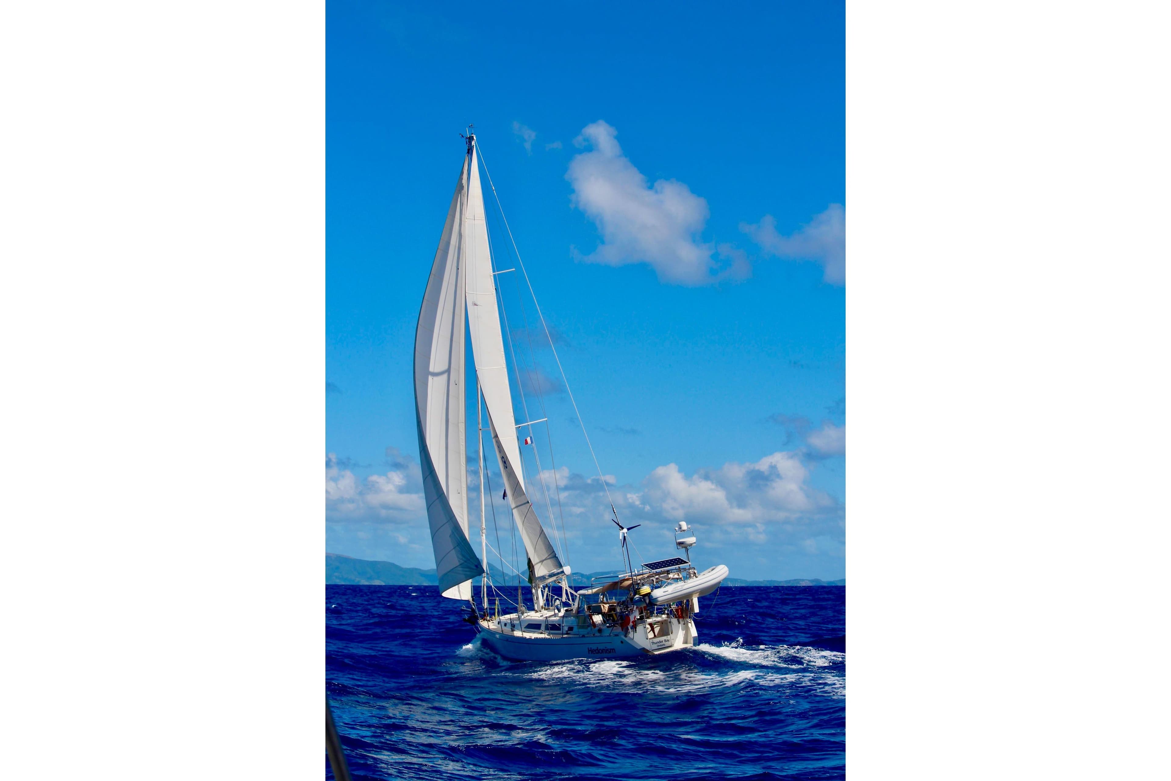 Sailing yacht Outbound 46 (2005) navigating blue ocean under clear skies.