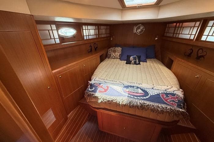 Luxurious 2007 Island Pilot 395 cabin with cozy bed and elegant wood paneling.