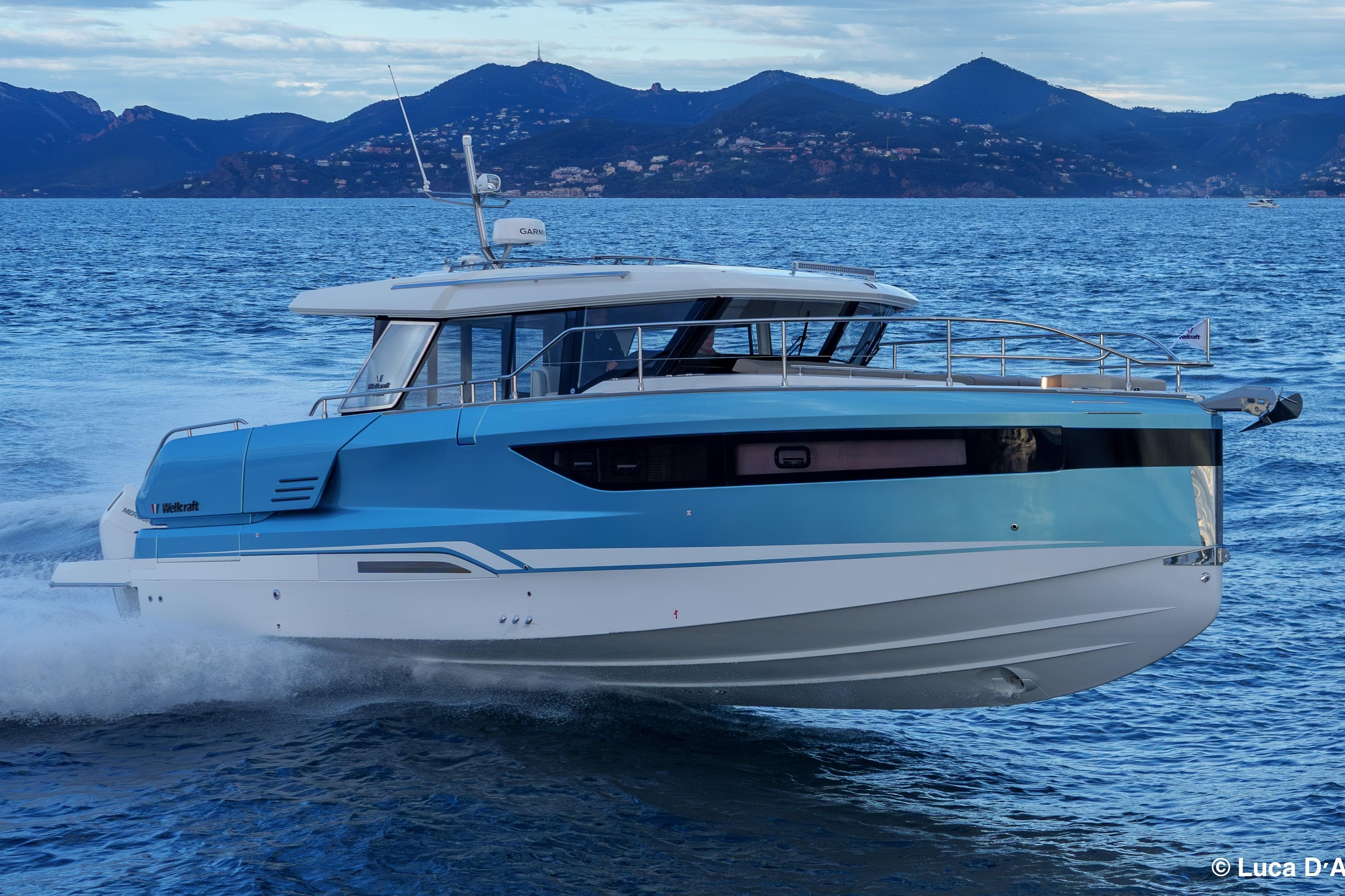 2026 Wellcraft 44 Explorer yacht cruising on open water with scenic mountain backdrop.