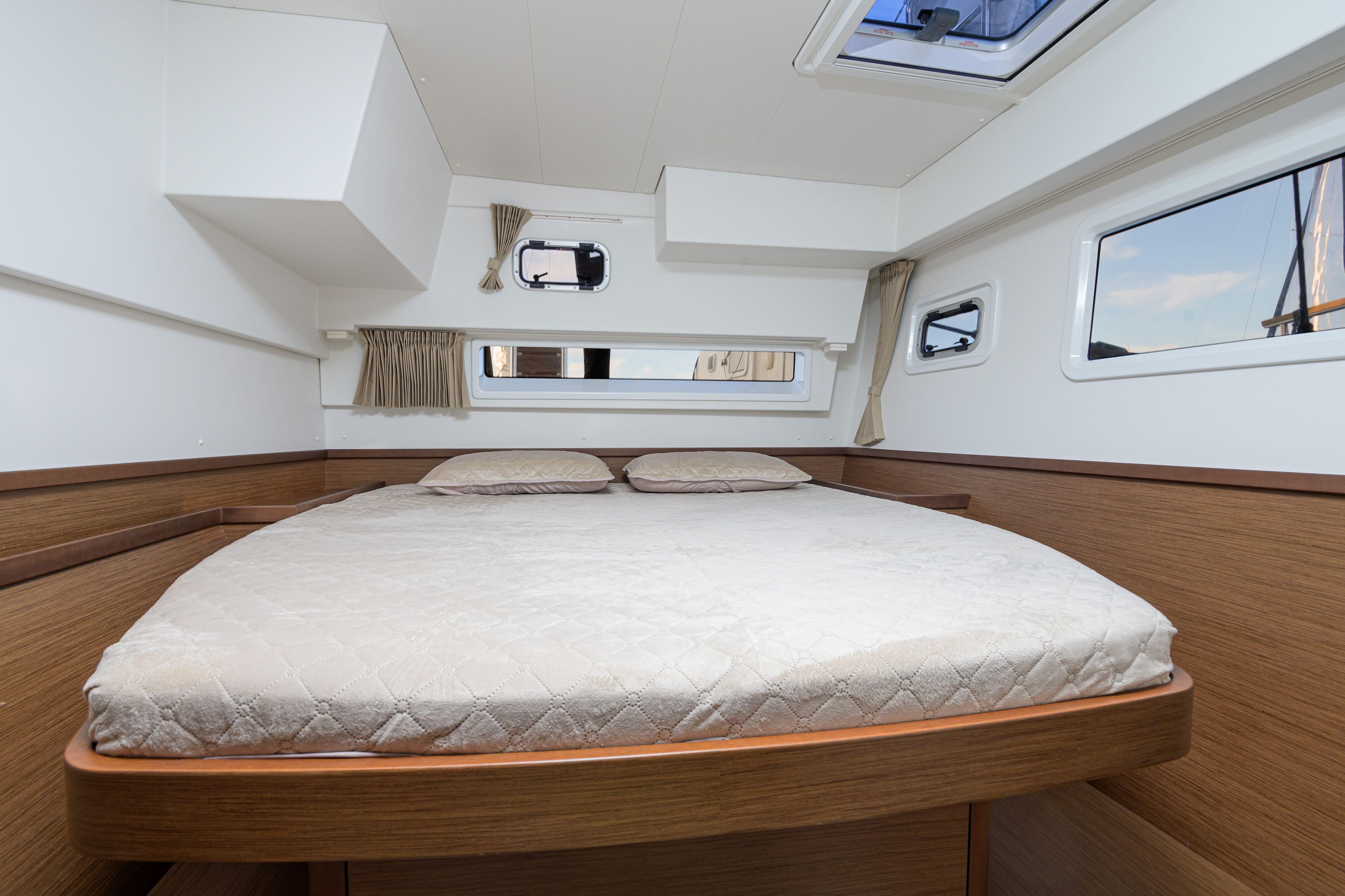 Luxurious cabin interior of 2019 Lagoon 42 catamaran with double bed and windows.