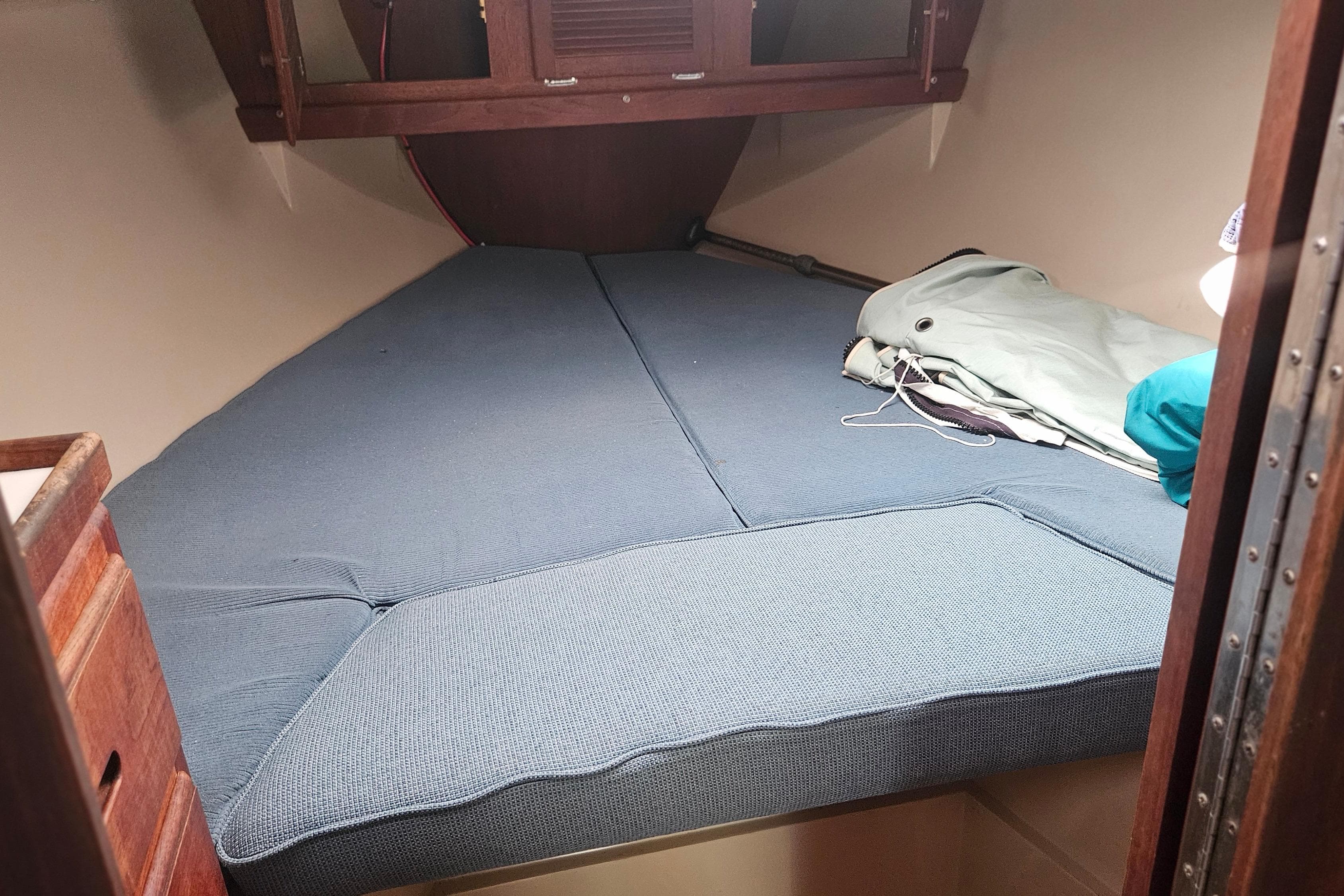 Interior cabin of 1988 Catalina 34 sailboat with blue cushions and storage space.