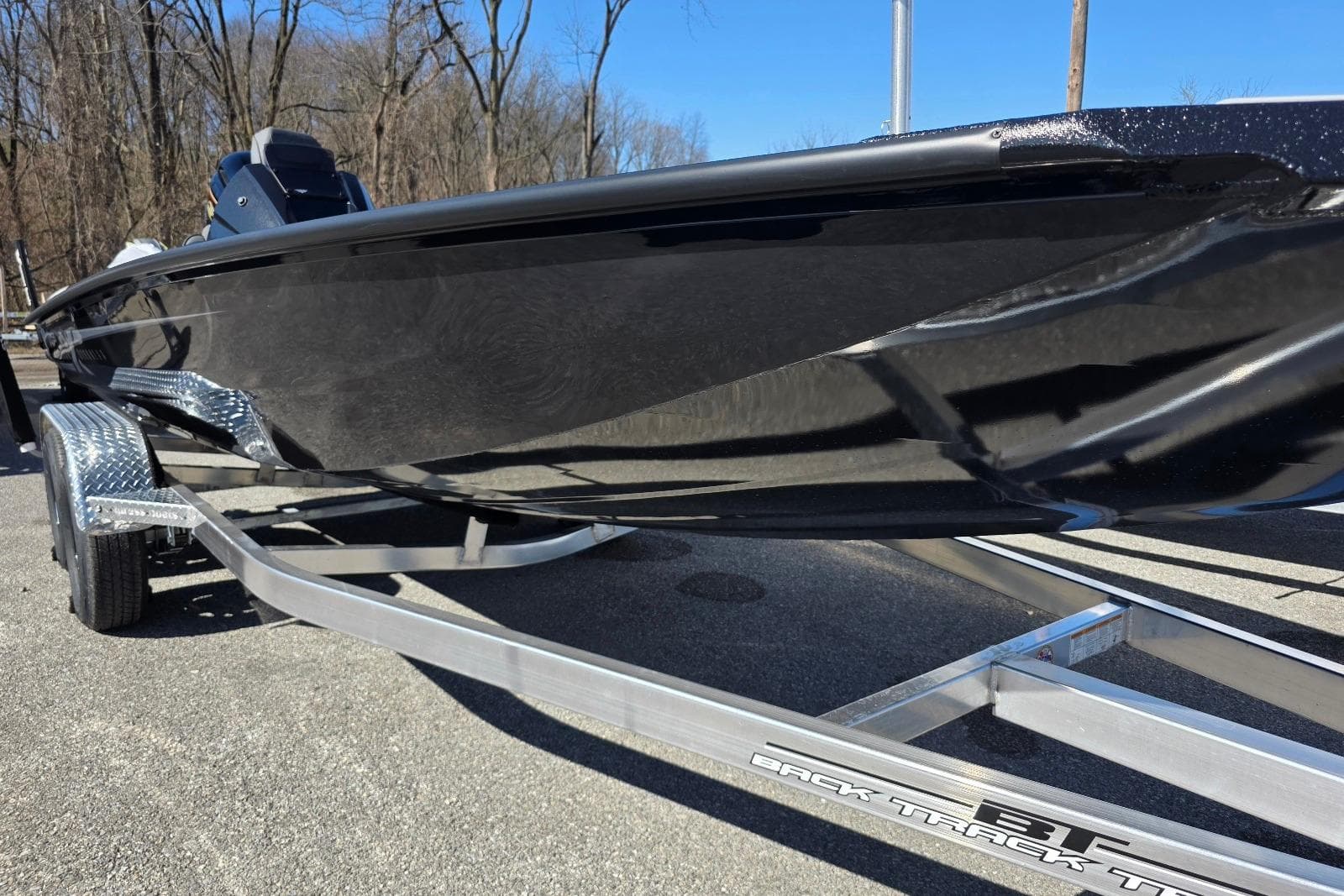 2026 Xpress H20 Bass boat on trailer, sleek black design, parked outdoors.