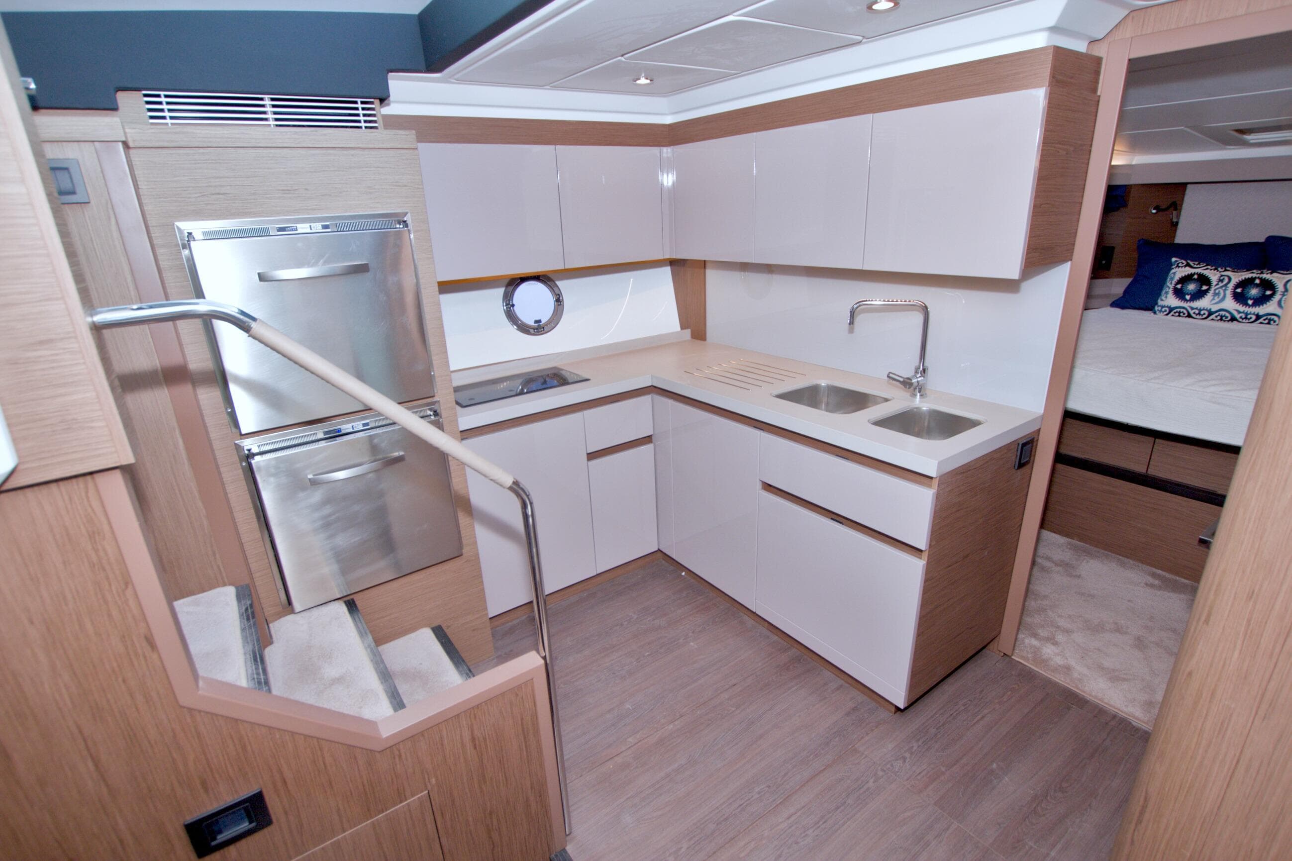Modern kitchen interior on 2019 Beneteau Gran Turismo 50 yacht, featuring sleek cabinetry and dual sinks.