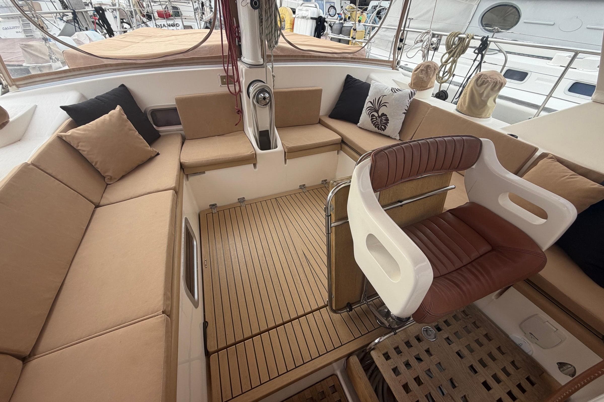 Luxurious Amel 54 yacht cockpit with cushioned seating and elegant wooden flooring, 2010 model.