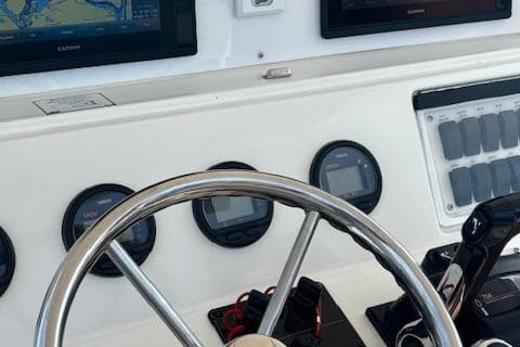 Steering wheel and dashboard of a 2004 Marlago FS35 boat with navigation instruments.