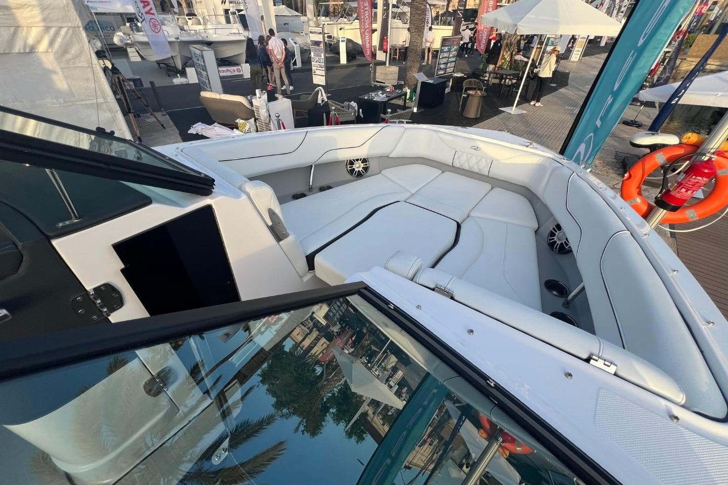 Luxurious 2025 Regal LS6 boat interior with white seating at a boat show.