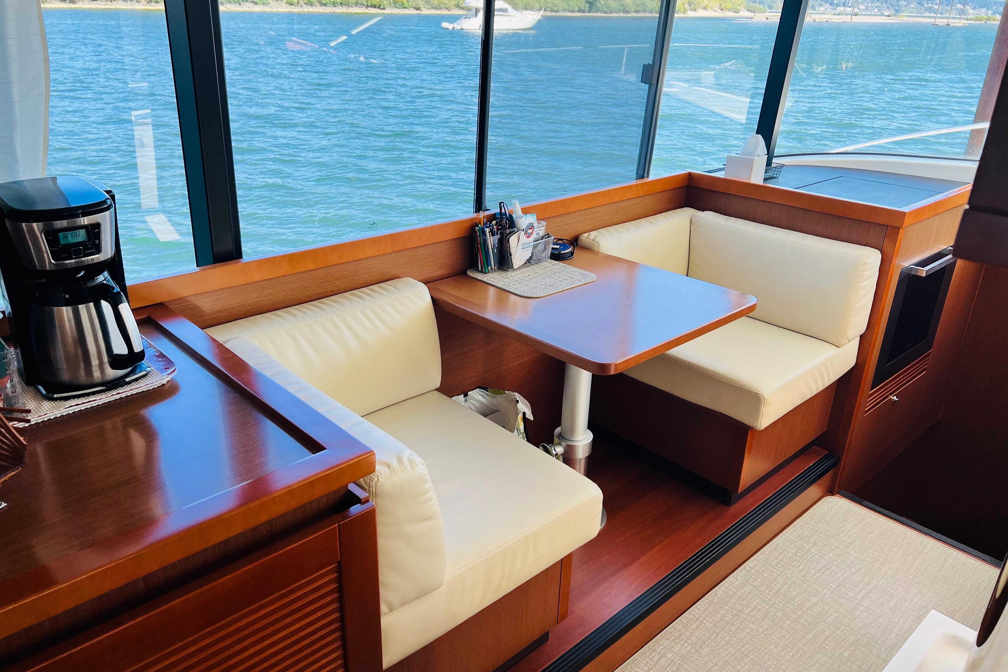 Interior of 2014 Beneteau Swift Trawler 50 with dining area and coffee maker.