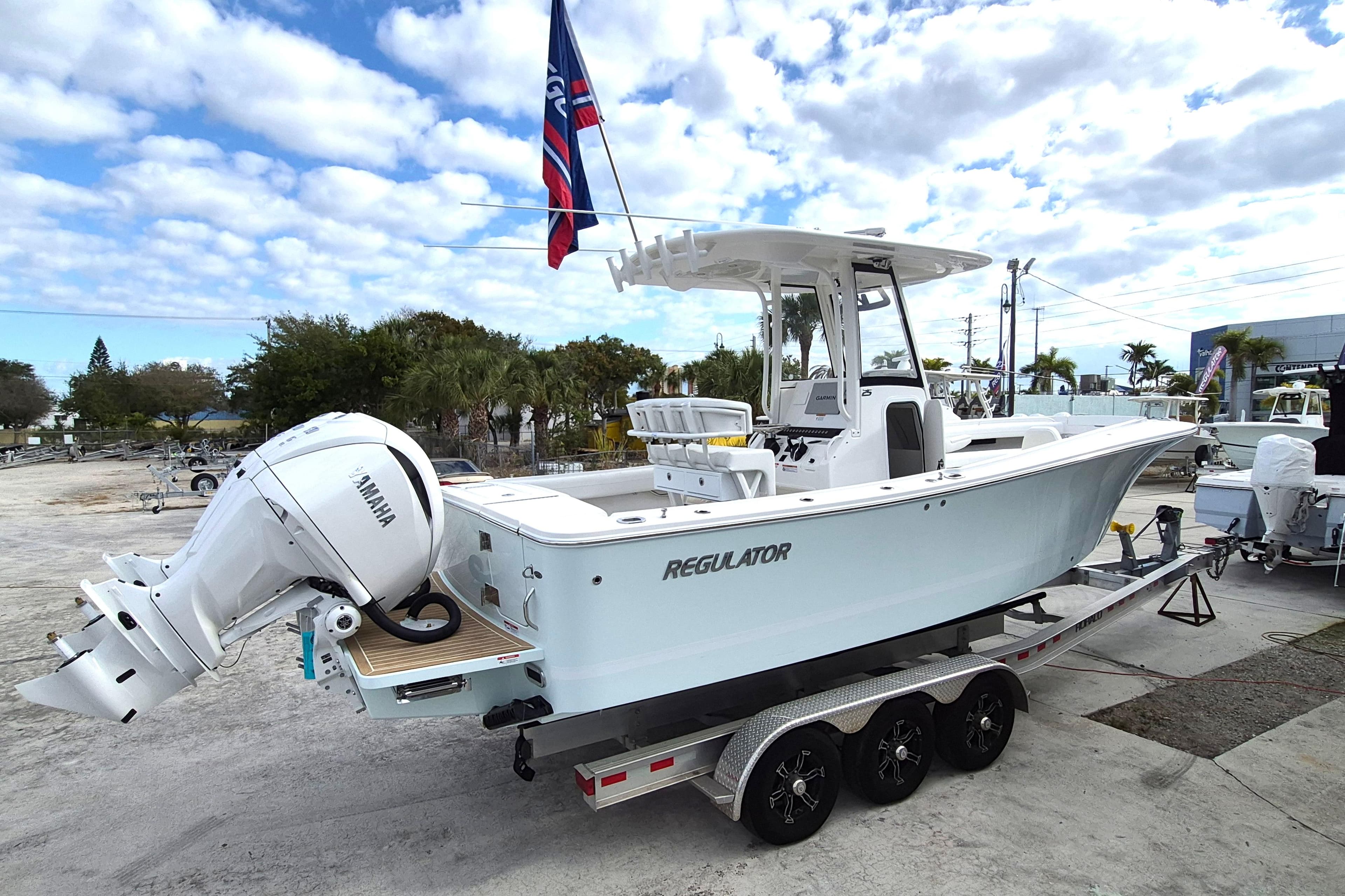 2026 Regulator 25 boat with Yamaha engine on trailer, under a partly cloudy sky.