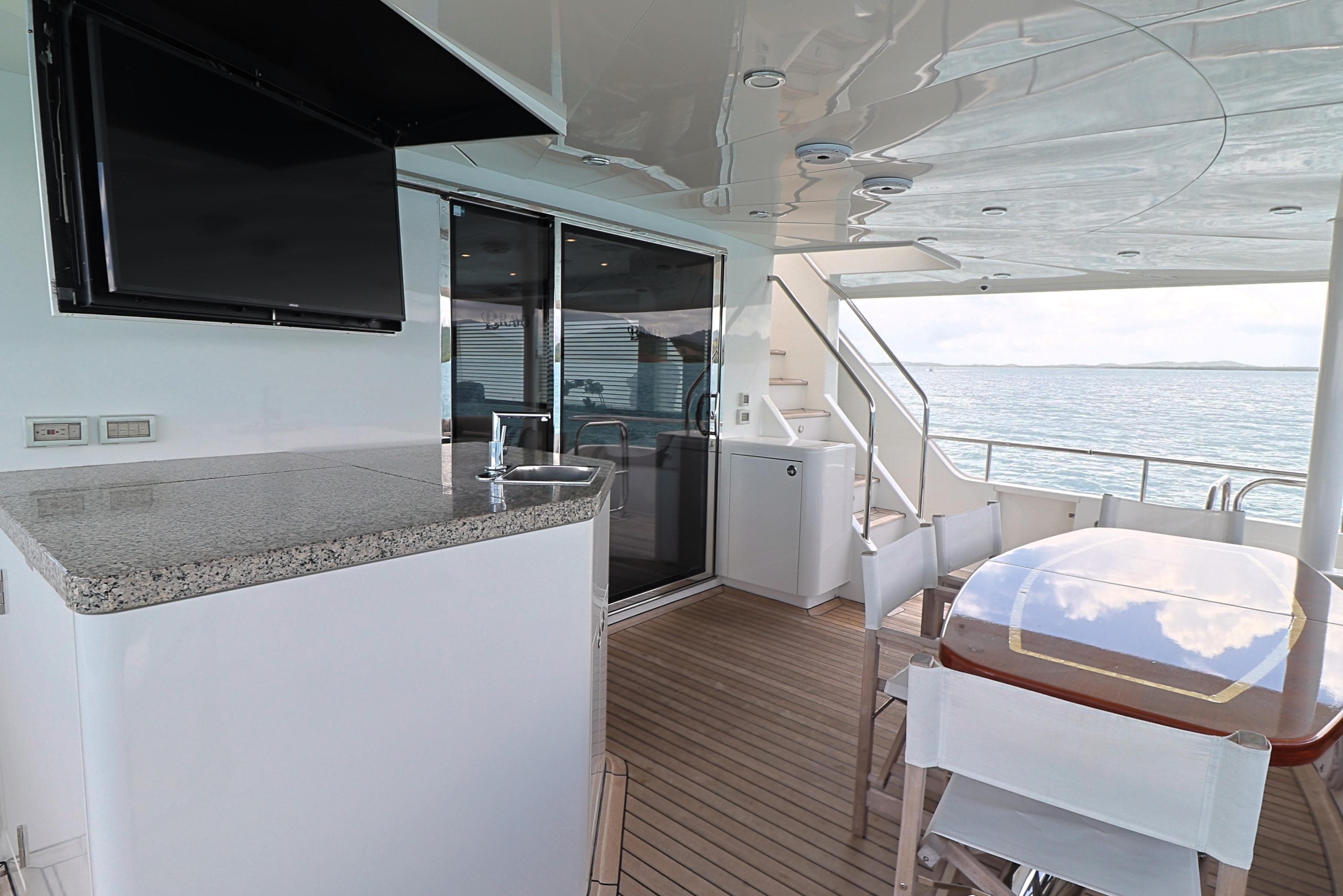 Luxurious 2013 Cheoy Lee Bravo yacht deck with dining area and ocean view.