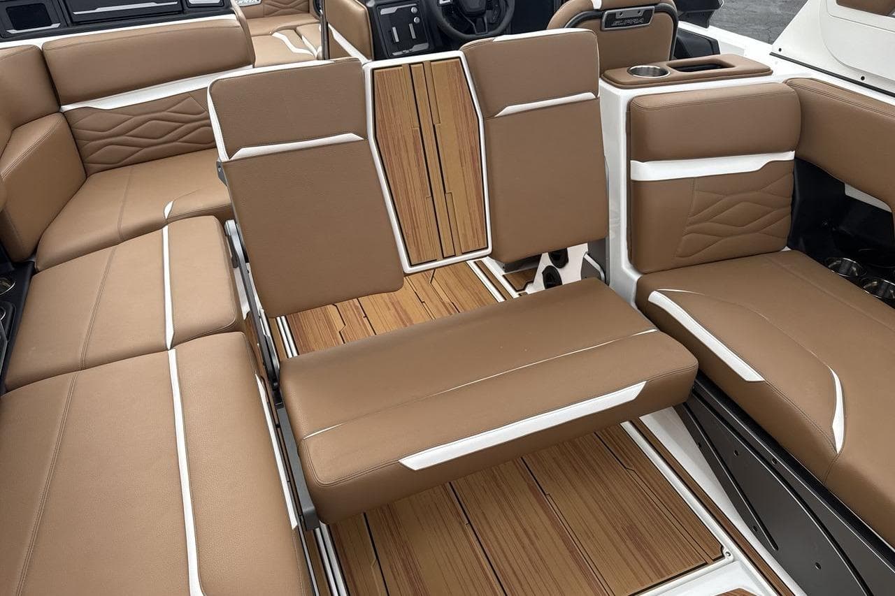 Luxurious 2026 Supra SV boat interior with brown leather seating and wood accents.
