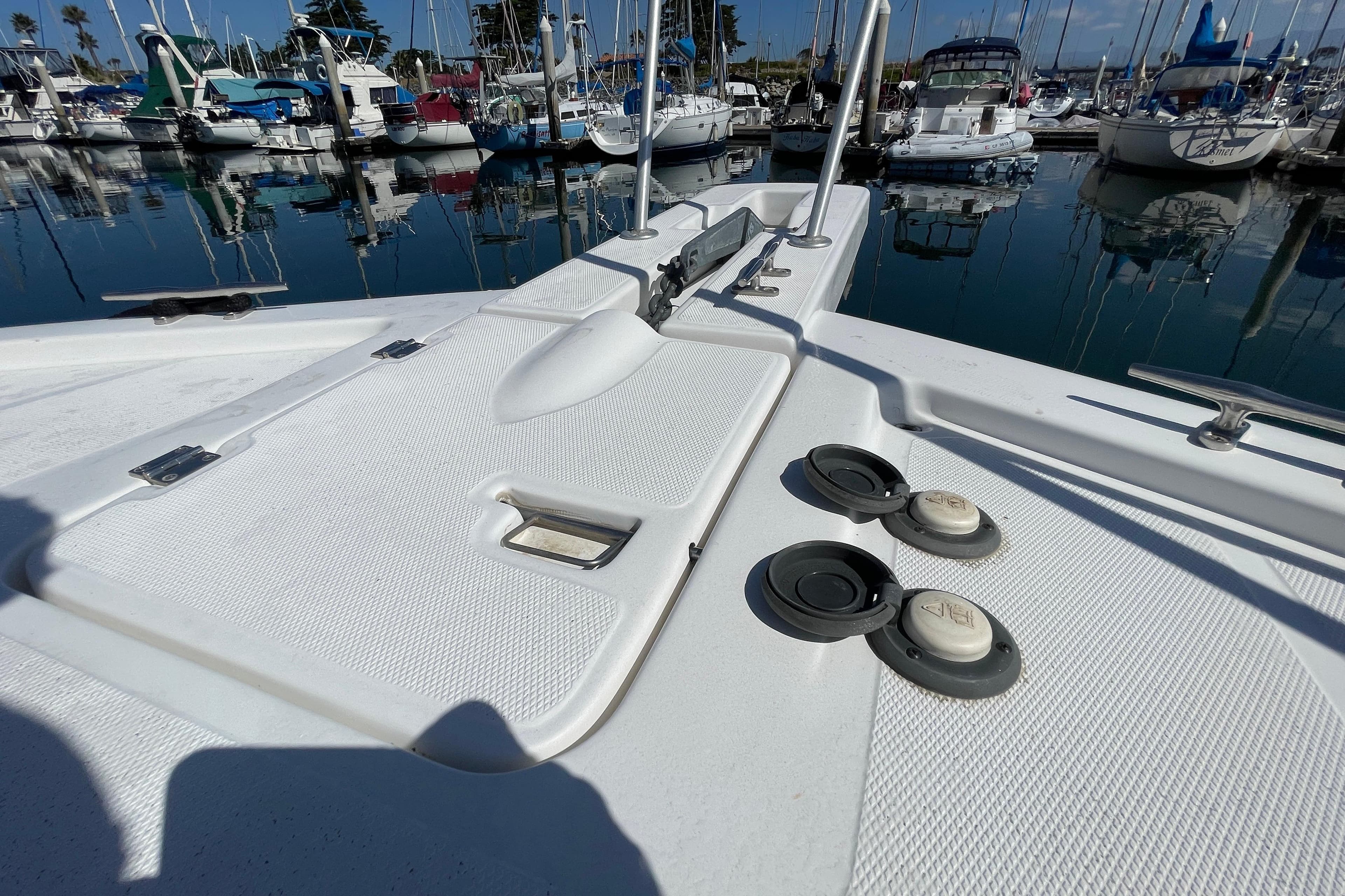 2003 Luhrs 34 Convertible boat deck with marina view, featuring hatches and cleats.