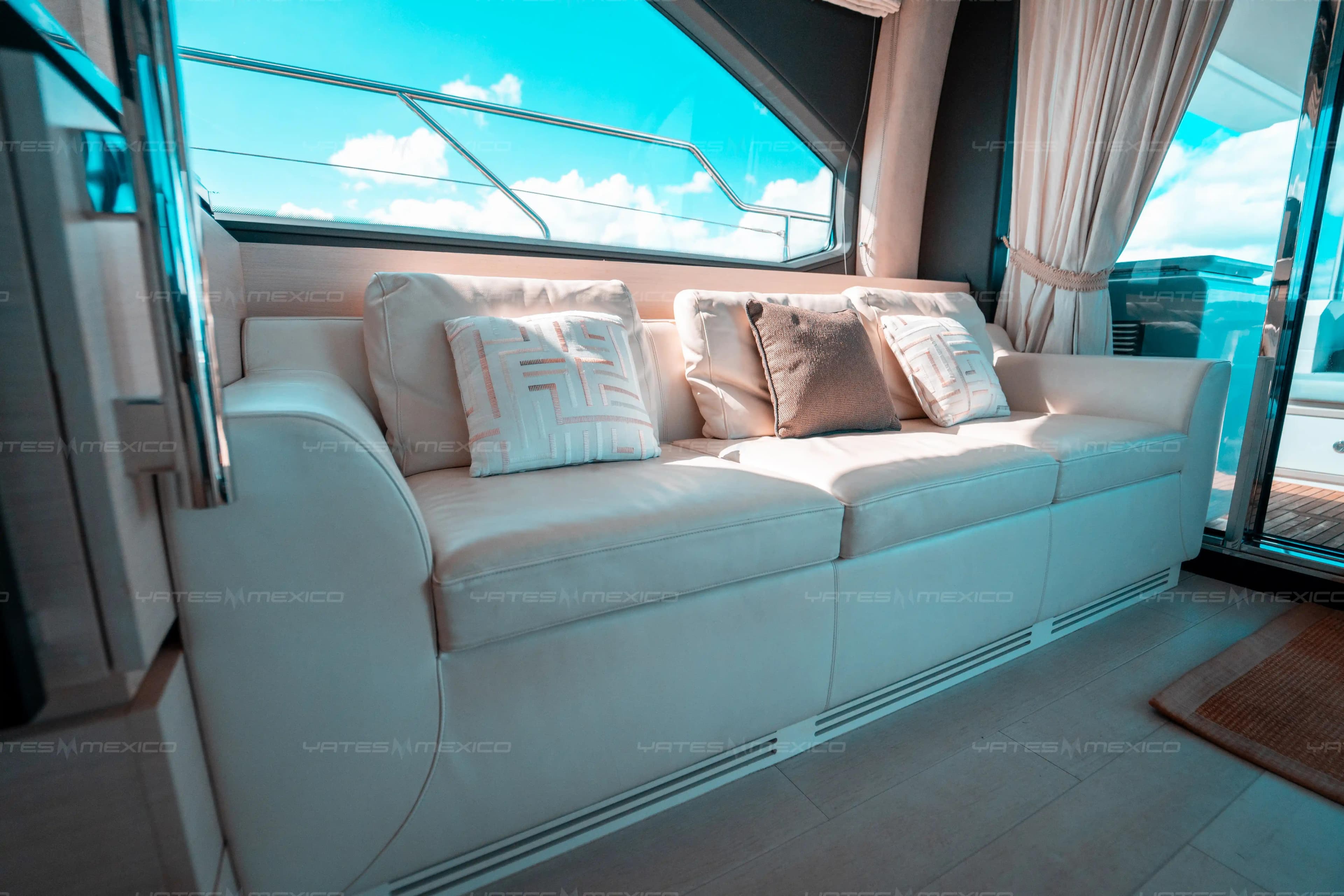 Luxurious interior of 2017 Azimut 66 yacht with plush white seating and decorative pillows.