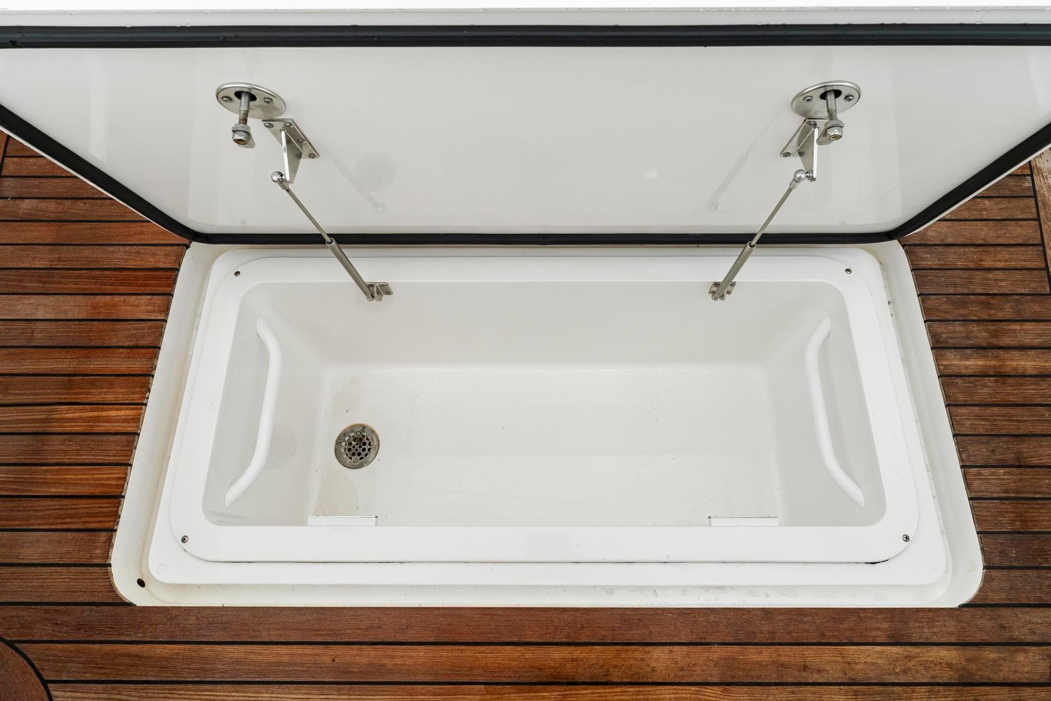 Open storage compartment on 2018 Viking 44 Express boat with wooden deck.