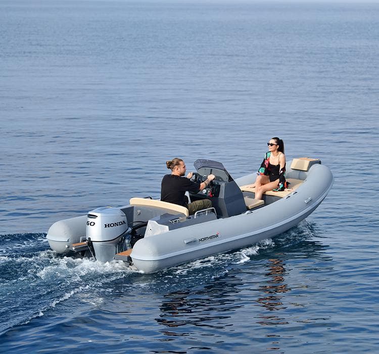 2024 Northstar Axis 4.8 boat cruising on calm water with two passengers.