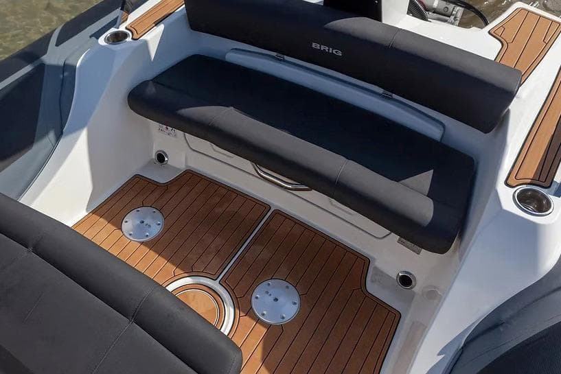 Manufacturer Provided Image: 2026 Brig Eagle 8 boat interior with sleek black seating and wooden flooring.