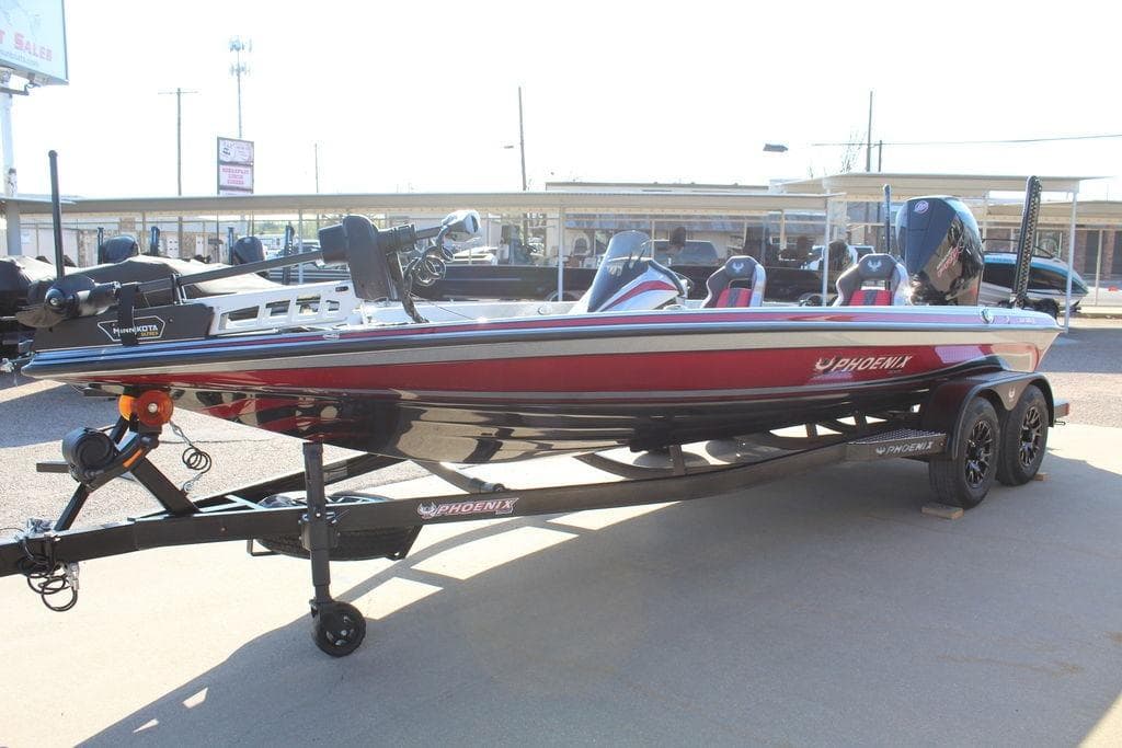 2026 Phoenix 921 Elite X boat on trailer, red and black design, parked outdoors.