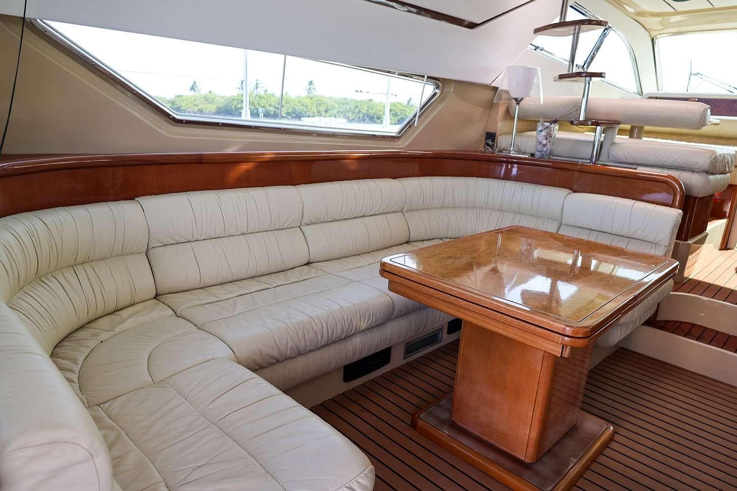 Luxurious interior of 1998 Ferretti Yachts 55 Motor Yacht with plush seating and wooden table.