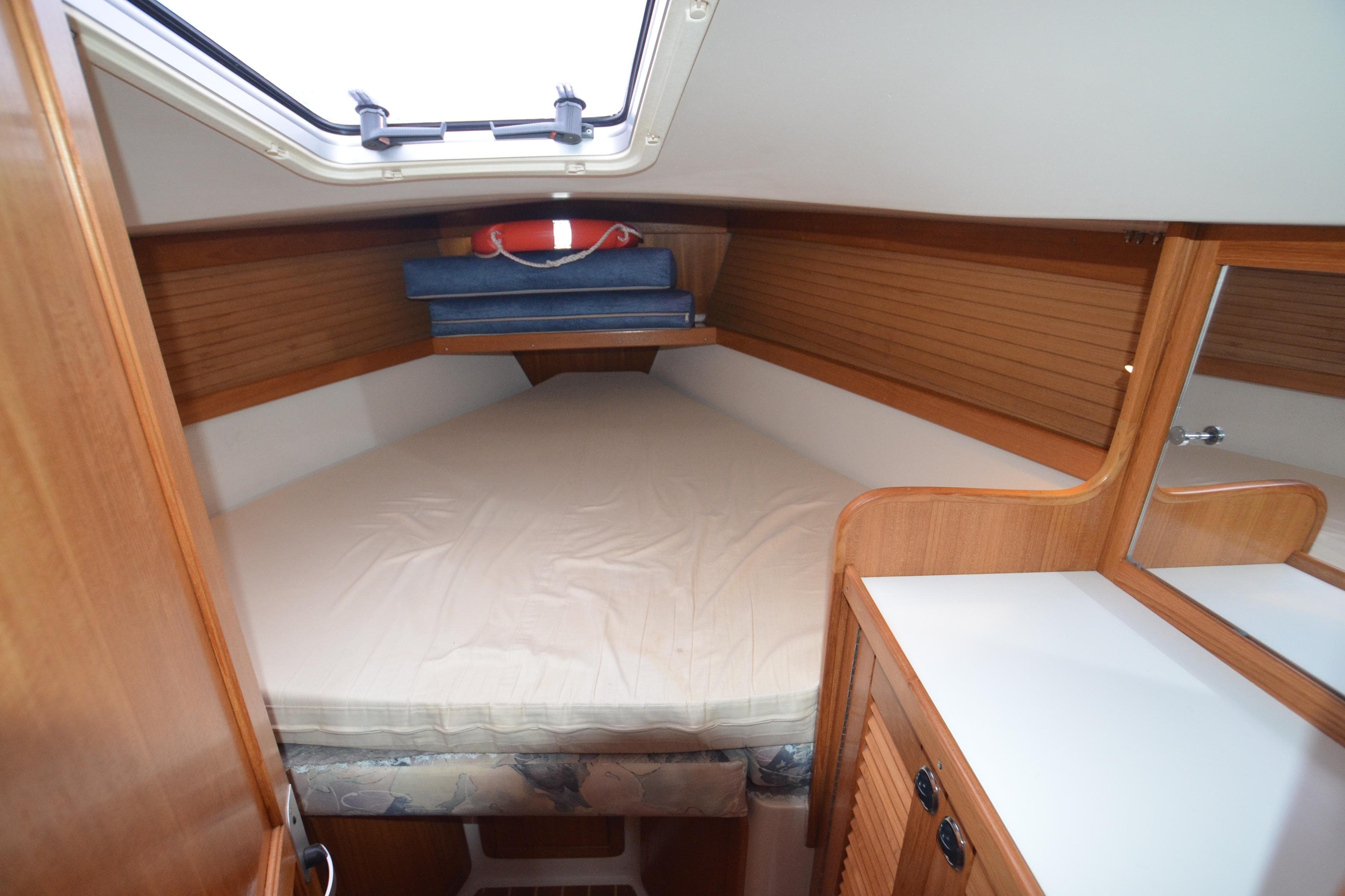Cozy cabin interior of 2003 Catalina 36 MkII sailboat with wooden finish and bedding.