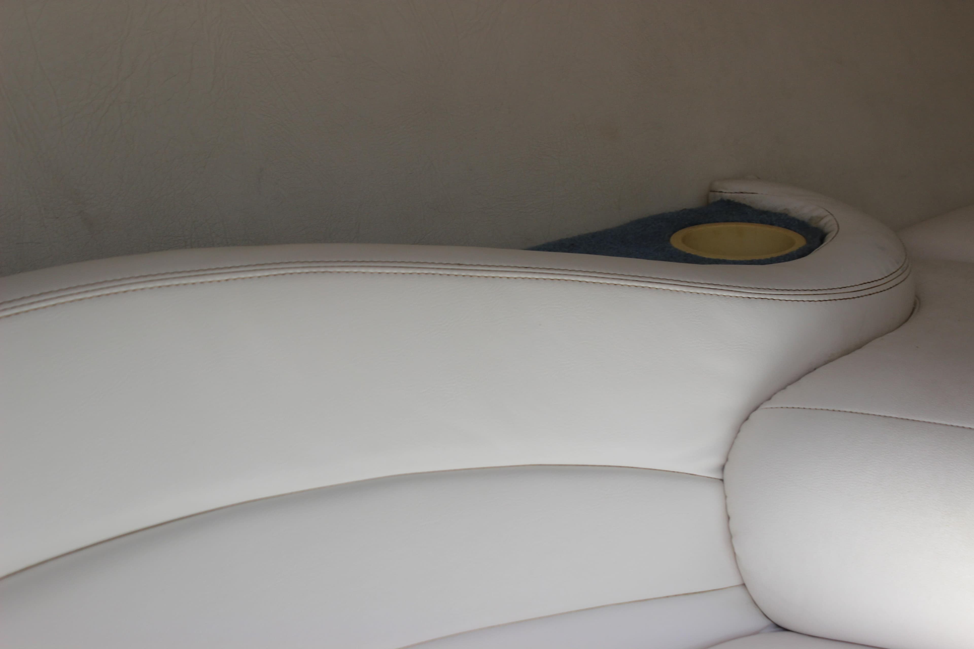 White leather seating with cup holder on a 1995 Baja 272 boat.