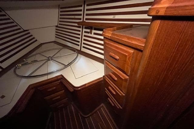 Interior of 1983 Endeavour 35 sailboat with wooden cabinetry and striped walls.