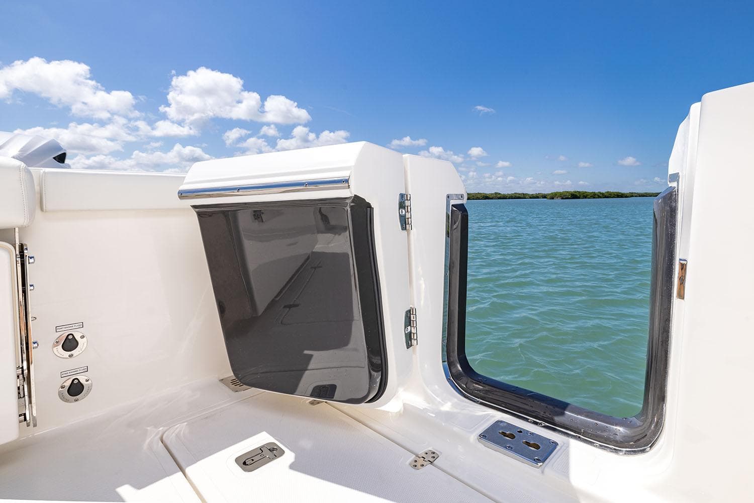 Manufacturer Provided Image: 2025 Pursuit OS 325 Offshore boat deck with open hatch, ocean view, and clear blue sky.