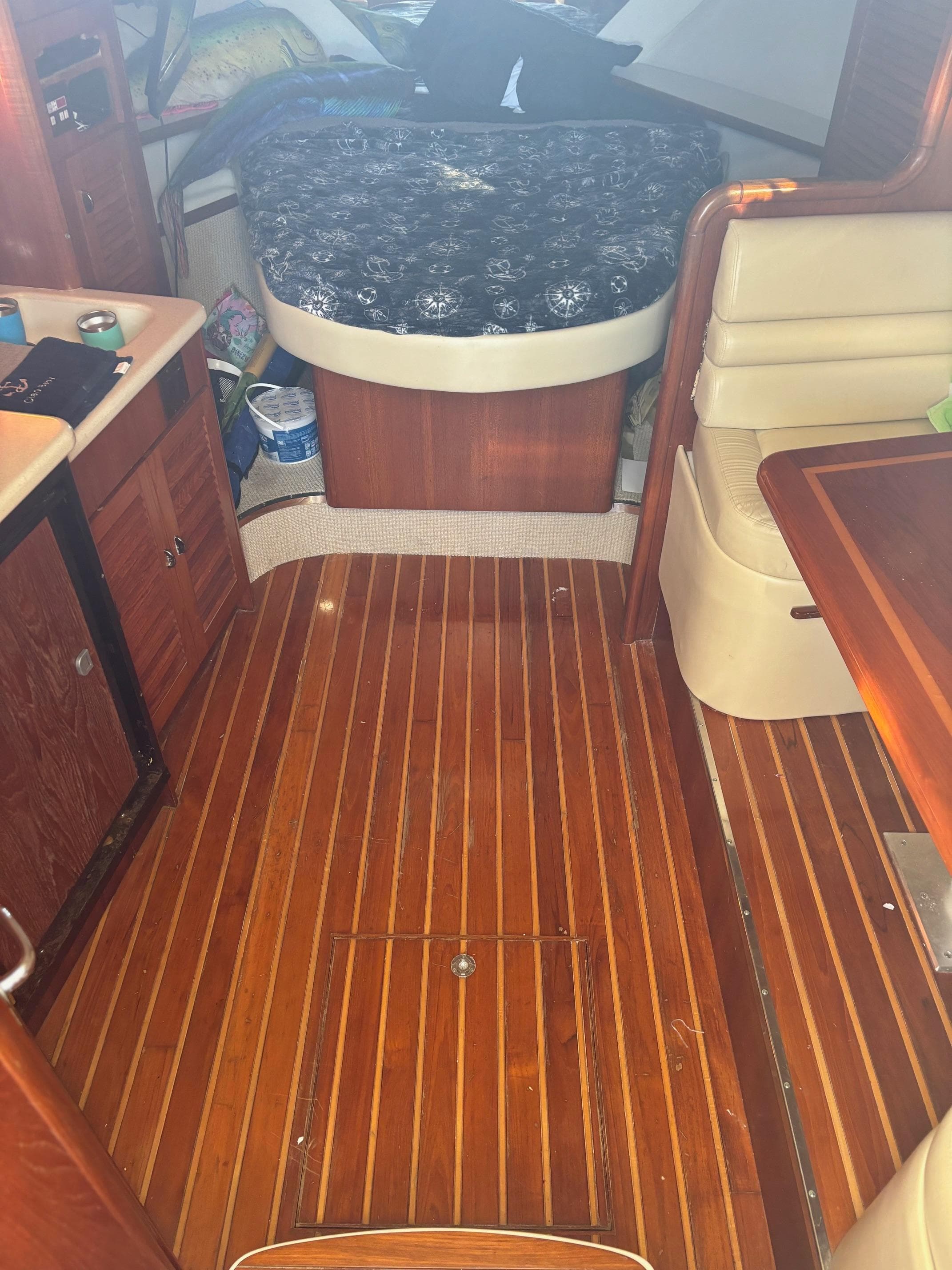 Interior of 2000 Pursuit 3400 Express boat with wooden flooring and cozy seating.