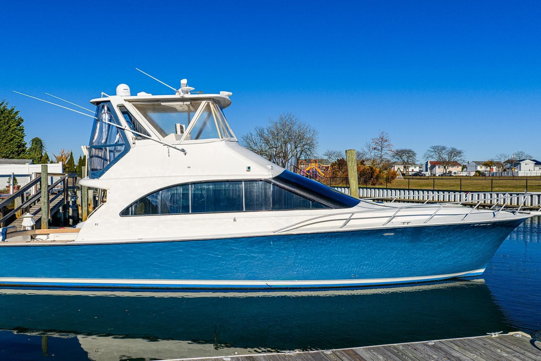 1998 Ocean Yachts 48 Super Sport docked, featuring sleek blue and white design.