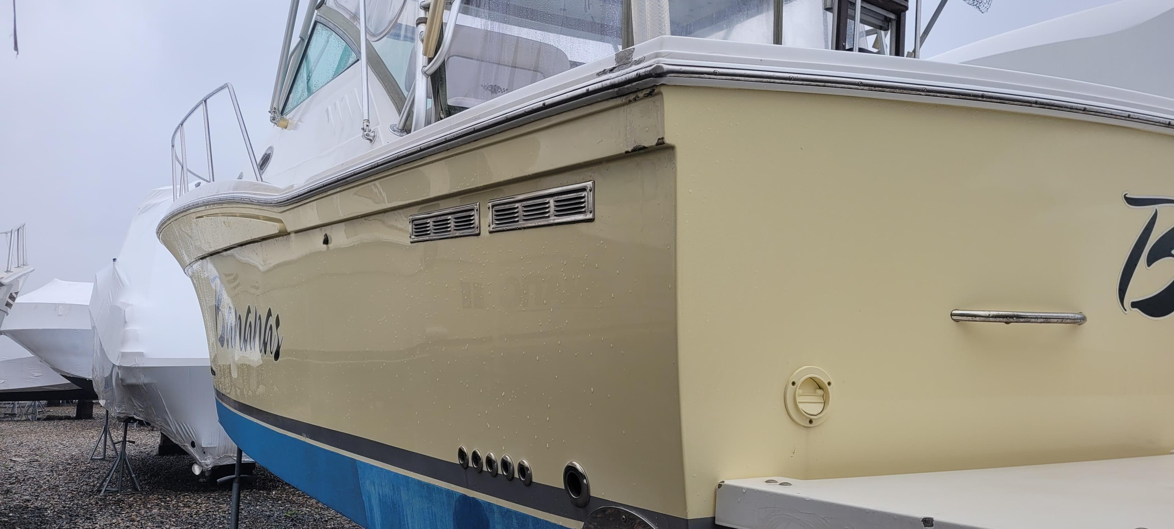 2006 Wellcraft 330 Coastal boat, yellow hull, docked in a marina.