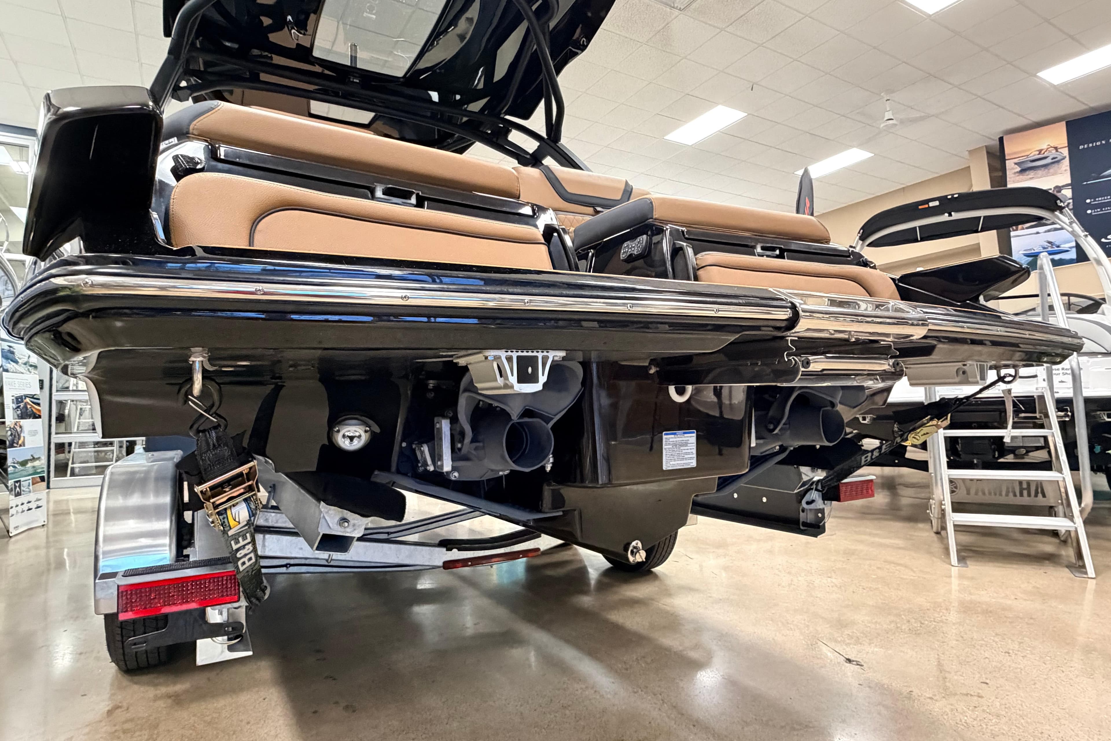 2026 Yamaha Boats 275SD rear view in showroom, showcasing sleek design and dual exhaust.