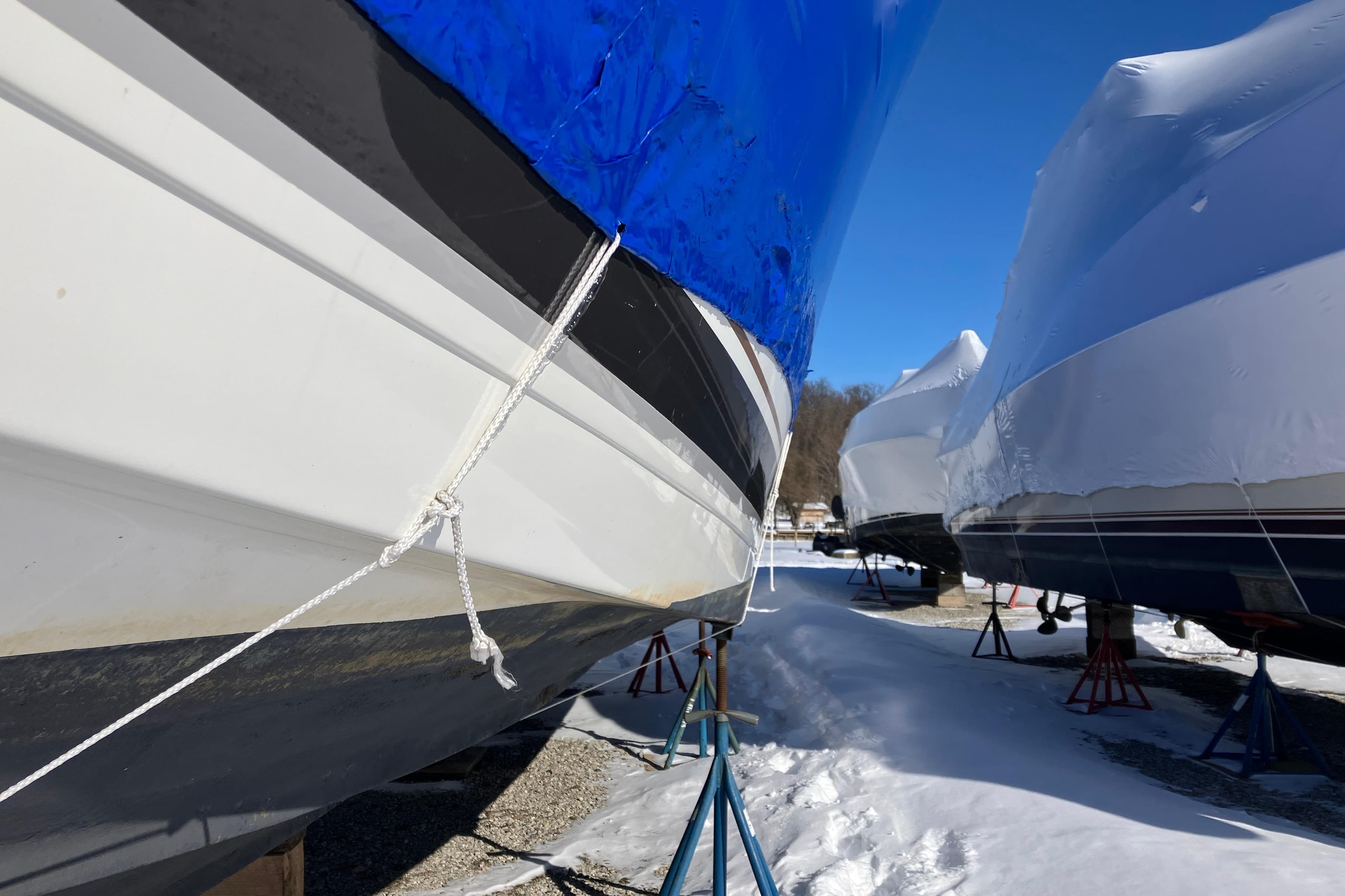 2001 Formula 37 Performance Cruiser boats in winter storage, covered and elevated on stands.