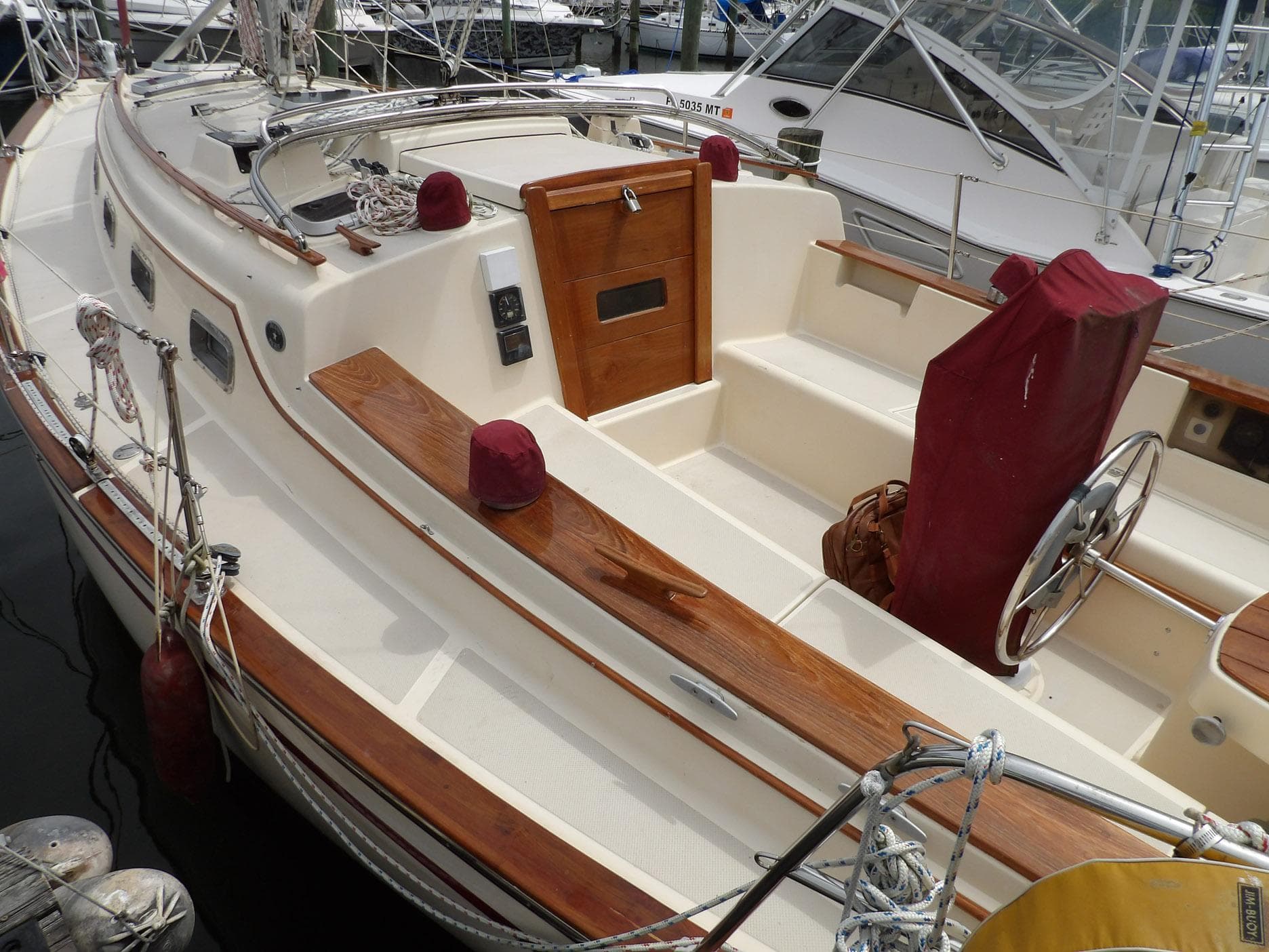 1990 Island Packet 32 sailboat with wooden accents and maroon covers, docked at marina.