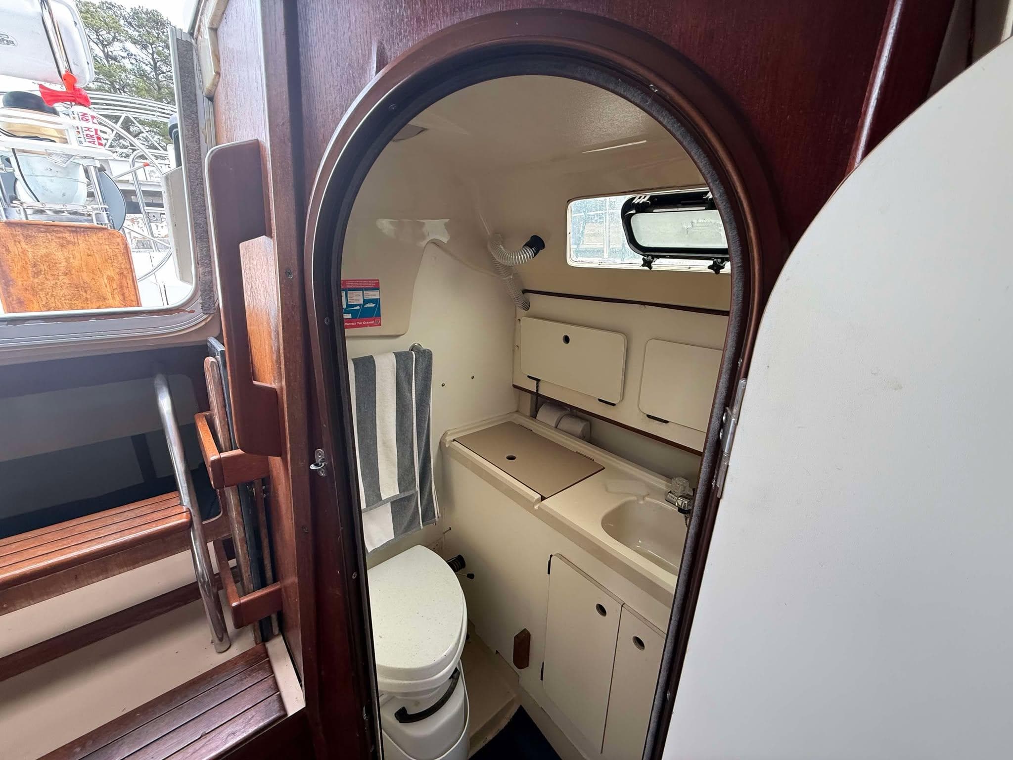 1988 Hunter 30-2 sailboat interior bathroom with toilet, sink, and storage cabinets.