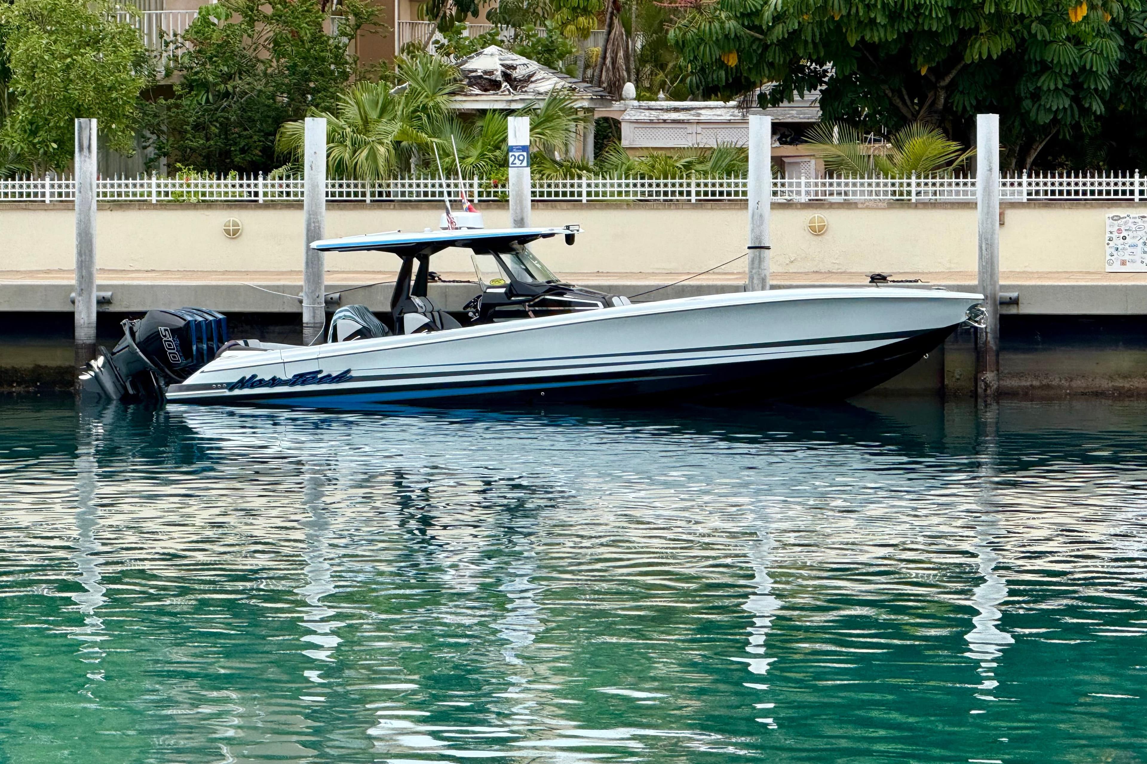2024 Nor-Tech 400 Supersport boat docked in clear turquoise water.