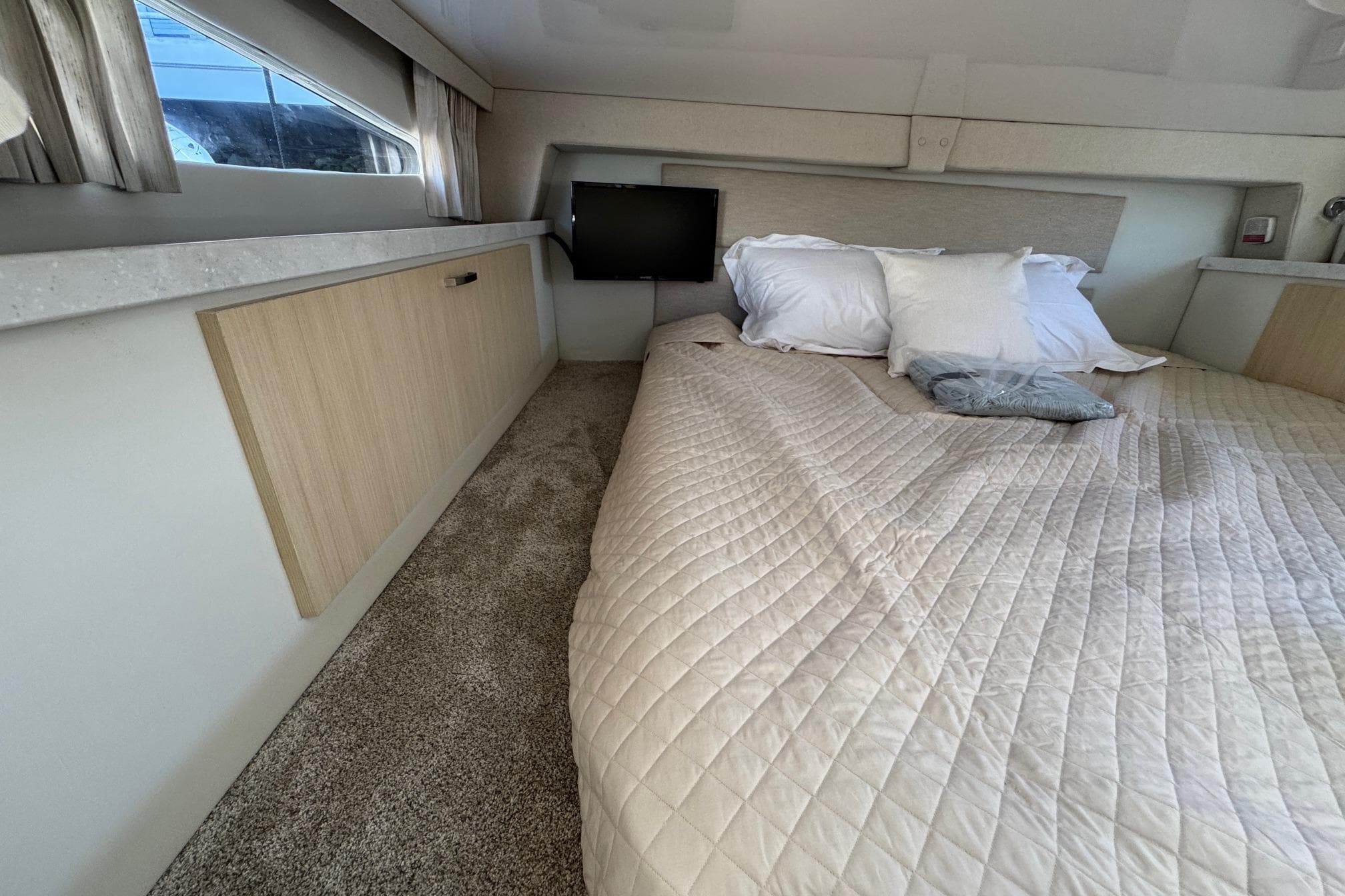 Luxurious interior cabin of 2026 Regal 33 XO yacht with cozy bedding.