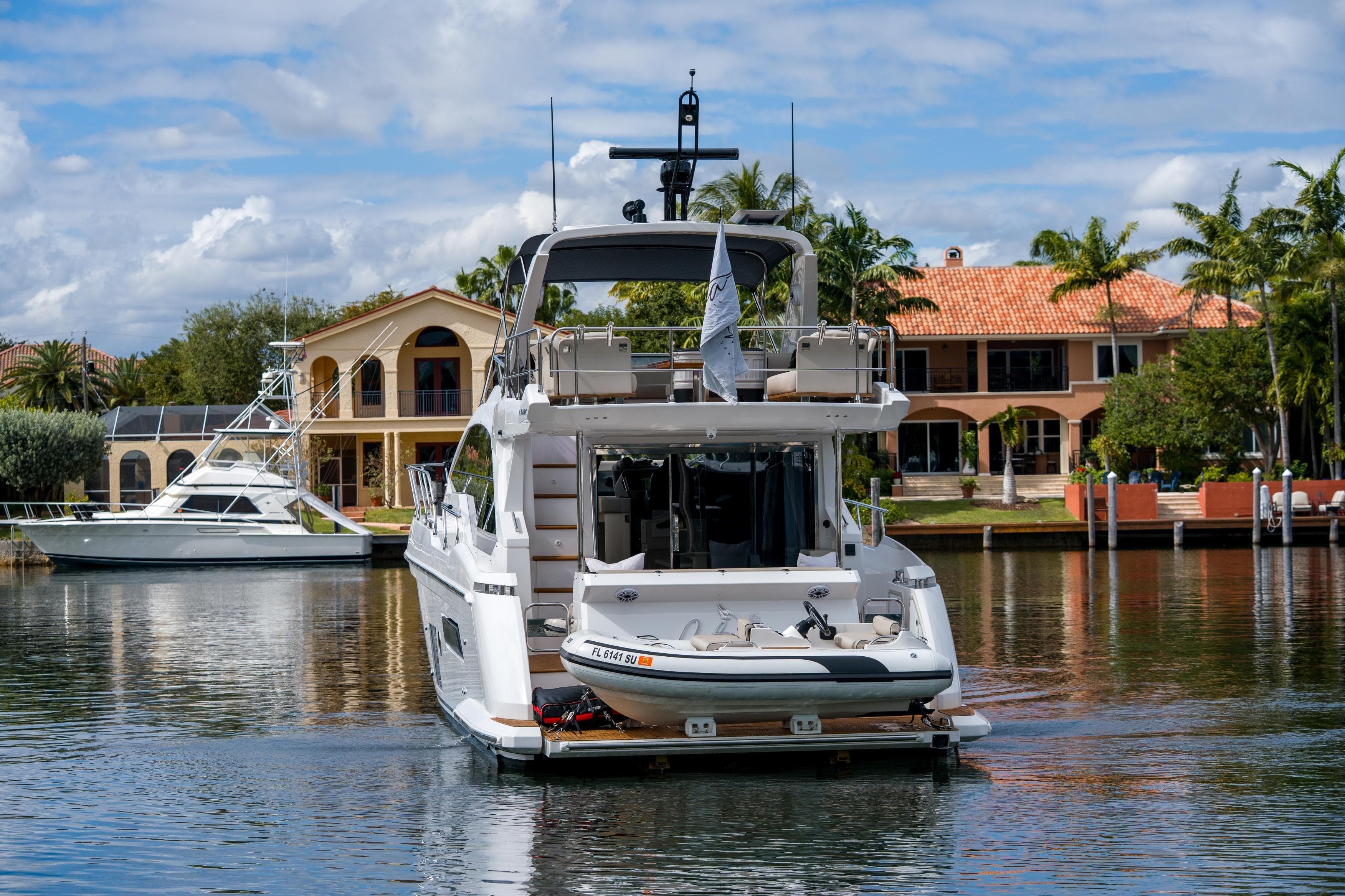 Azimut Fly 50 yacht, 2019 model, docked near luxury waterfront homes.