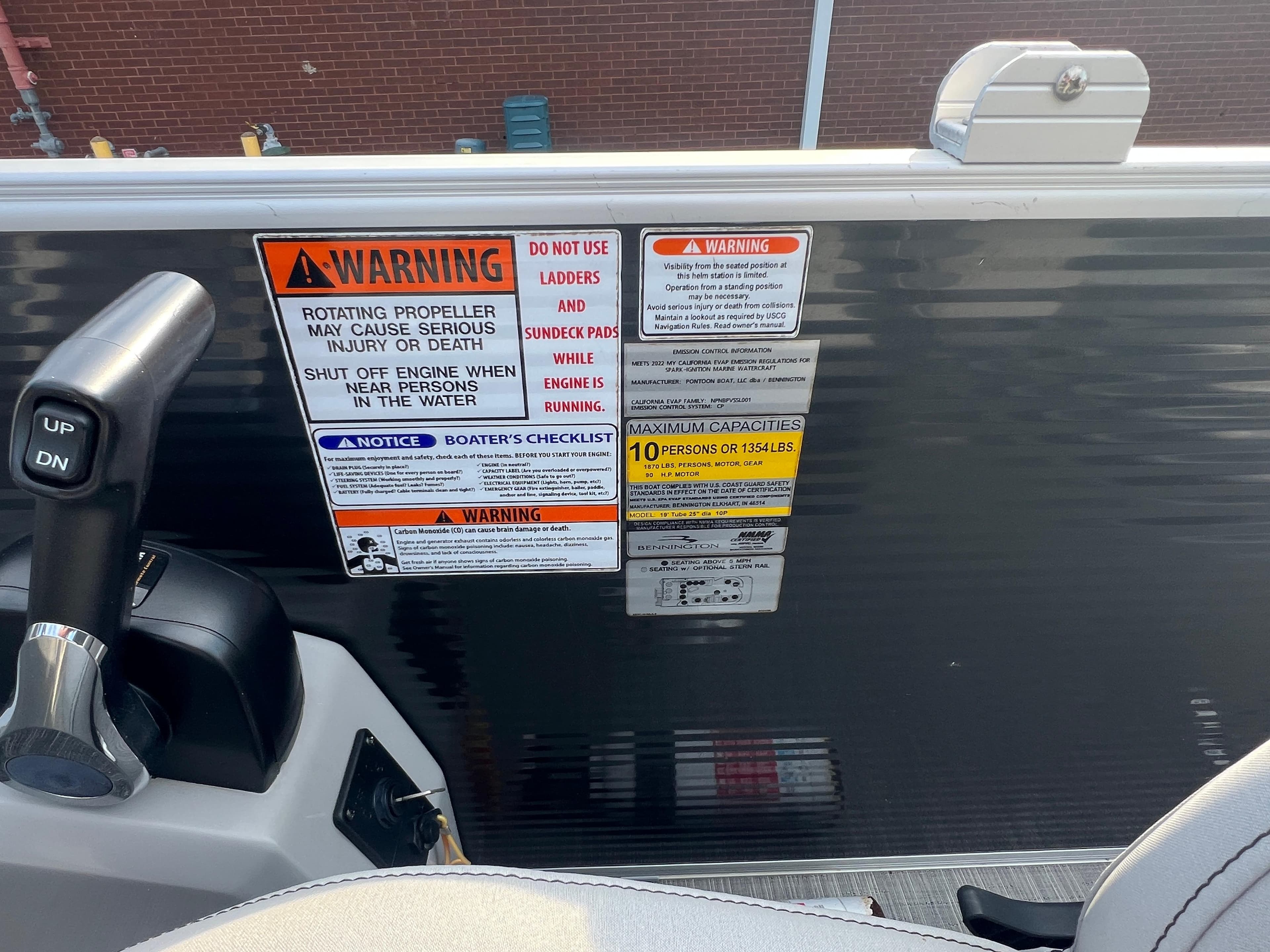 Warning labels and controls on a 2022 Bennington SX 20 Swingback boat.