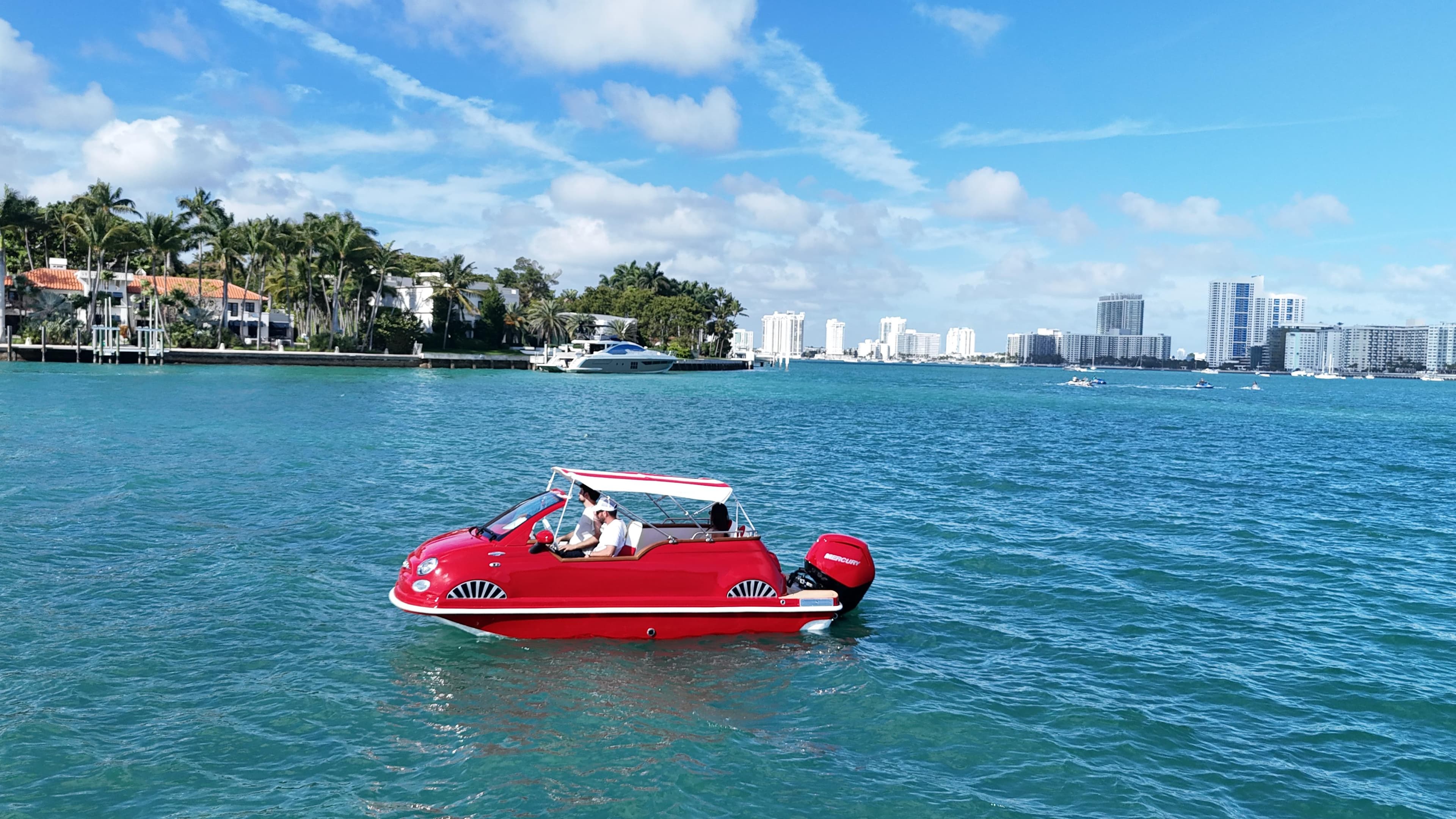 Red Car Off-shore Fiat 500 Classic boat on blue water, city skyline in background, 2025 model.