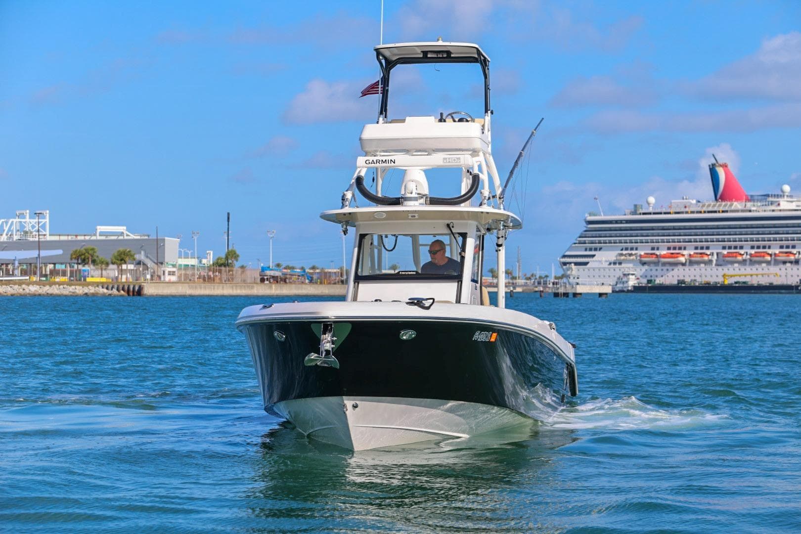 2017 Everglades 355 Center Console boat cruising near a large cruise ship in a harbor.