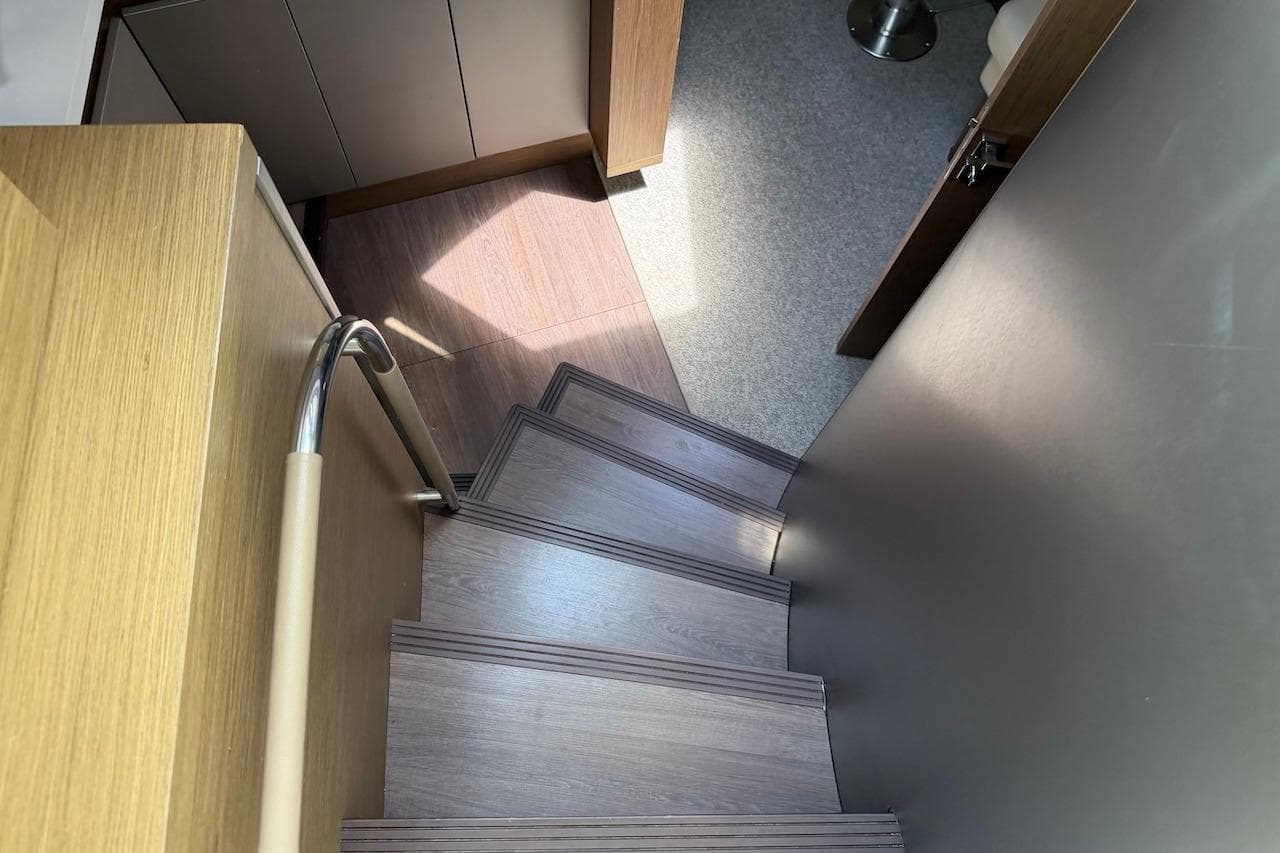 Staircase inside 2018 Beneteau Gran Turismo 46 yacht, featuring sleek wooden steps and modern design.