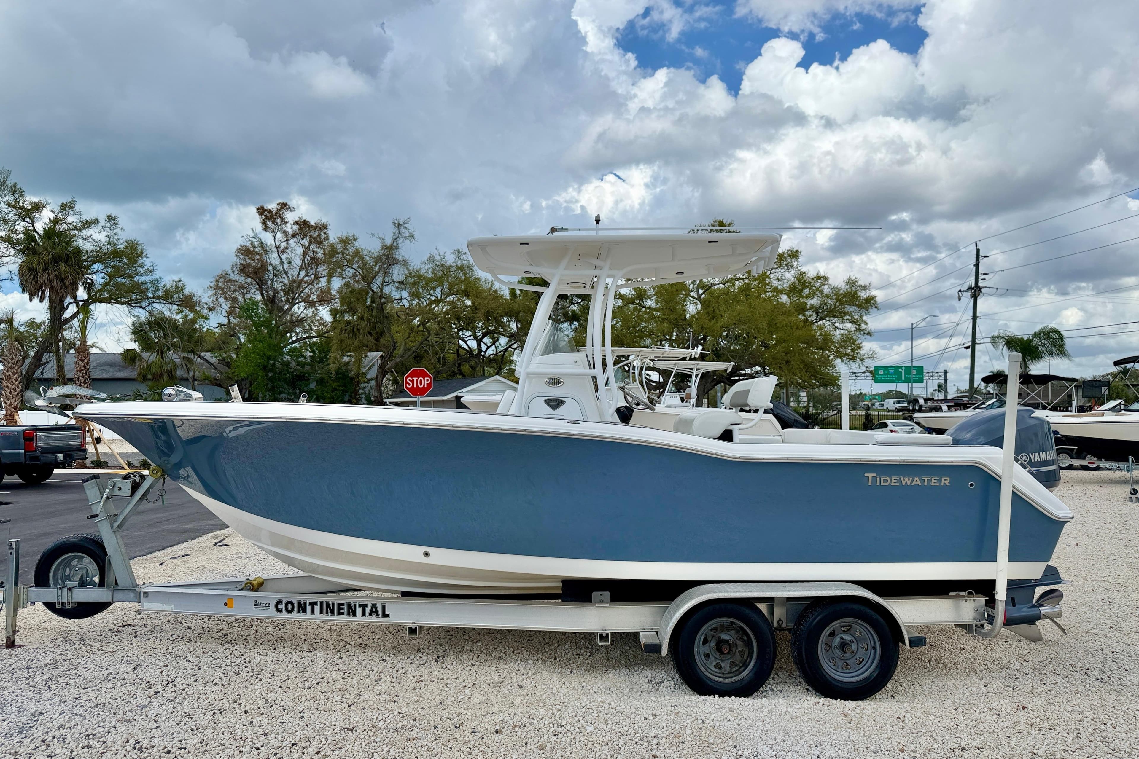 2014 Tidewater 230 LXF boat on trailer, parked outdoors under cloudy sky.