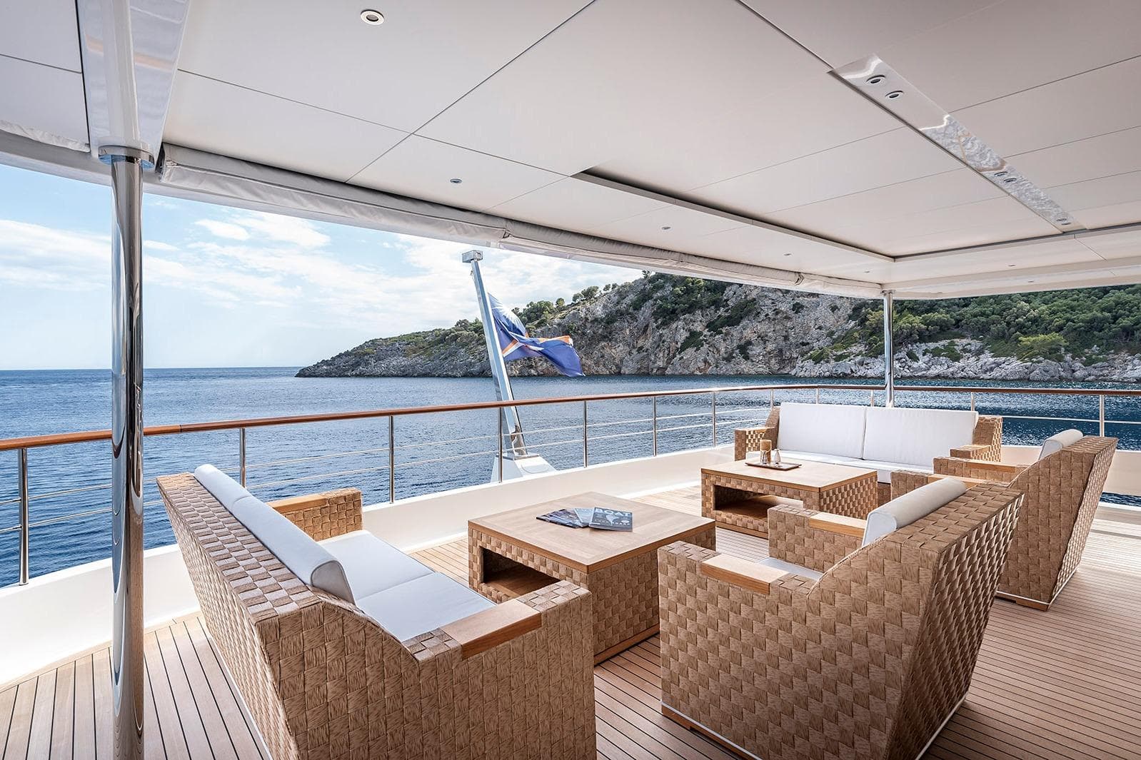 Luxurious Yildiz 141 yacht deck with elegant seating, overlooking serene ocean and rocky coastline, 2019 model.