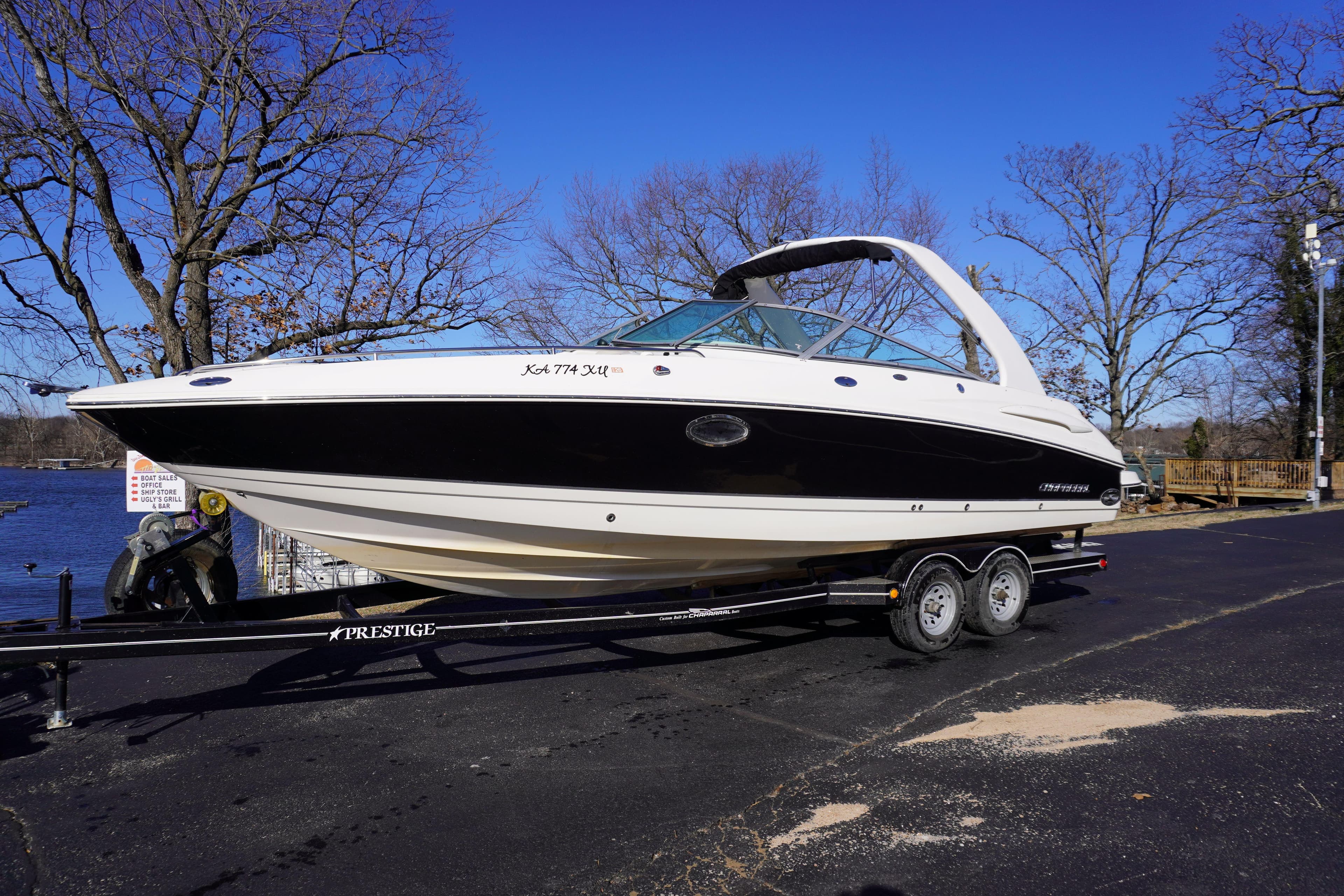 2006 Chaparral 280SSi boat on trailer, parked outdoors on a sunny day.